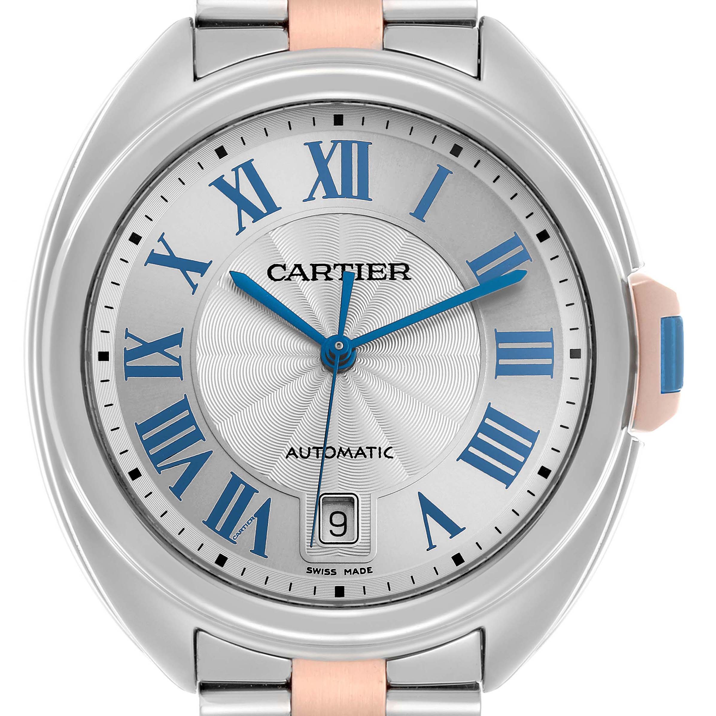 The Cartier Clé watch is shown from the front, highlighting the face, blue Roman numerals, hands, and date window.