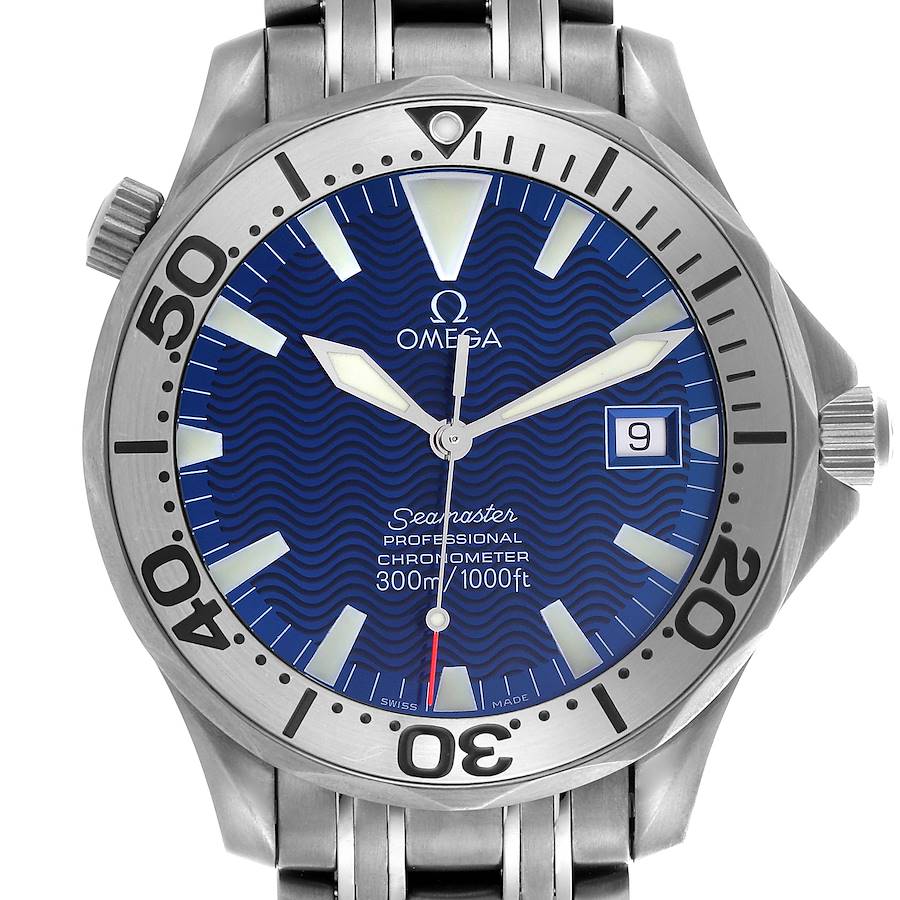 The image shows a front view of an Omega Seamaster watch, highlighting the blue dial, bezel, and part of the stainless steel bracelet.