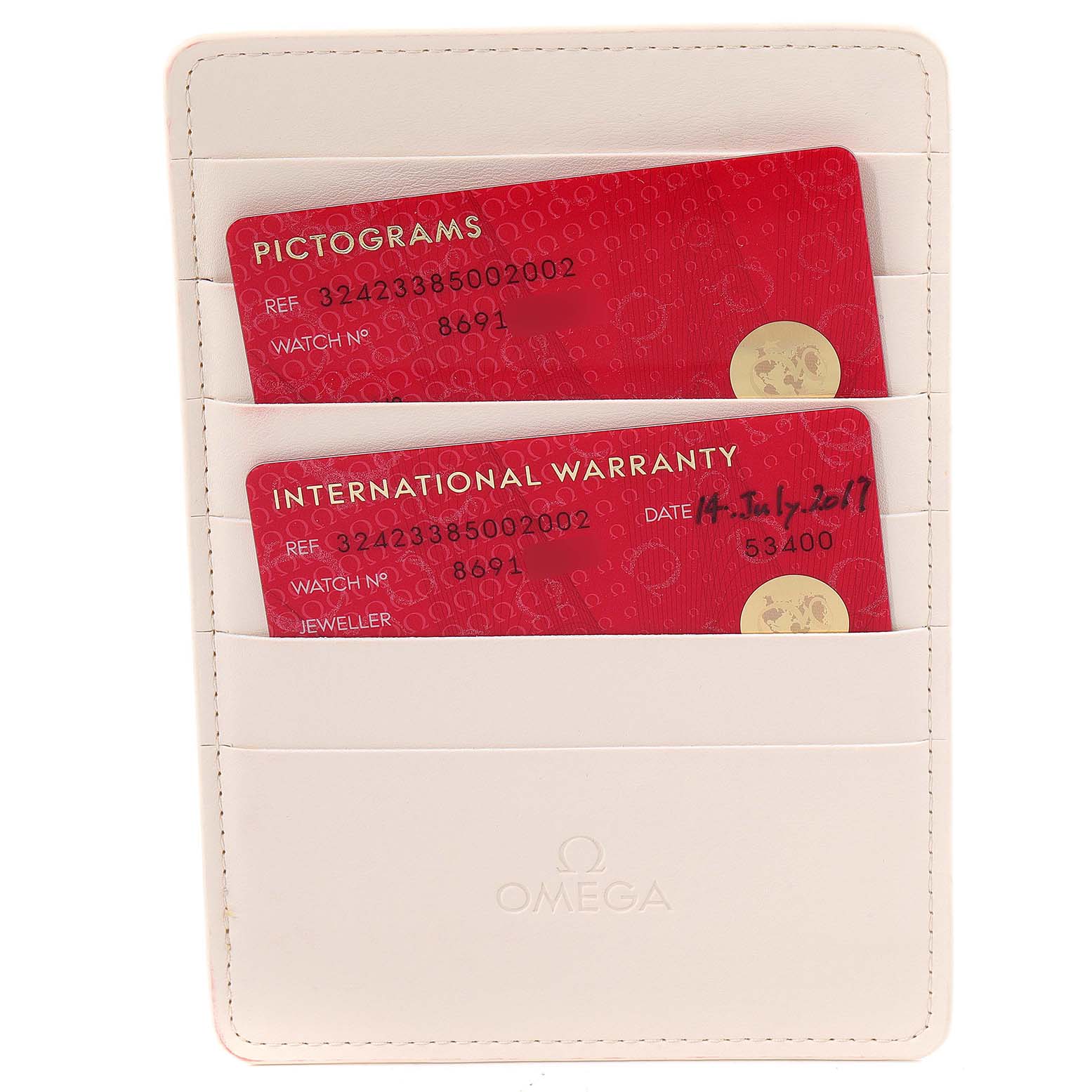 The image shows a white Omega card holder with pictogram and international warranty cards for the Speedmaster model.