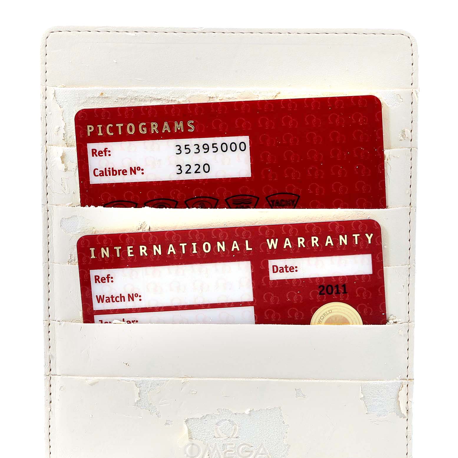 The image shows the international warranty and pictograms cards for an Omega Speedmaster 3539.50.00 Men
s Stainless Steel Black Dial 3539.50.00 Men
s Stainless Steel Black Dial watch in a white cardholder.