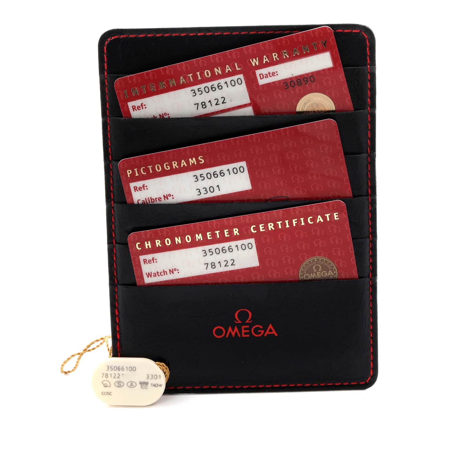 The image shows accessories for the Omega Speedmaster 3506.61.00 Men
s Stainless Steel Red Dial 3506.61.00 Men
s Stainless Steel Red Dial, including warranty cards and a tag, from a top-down angle.