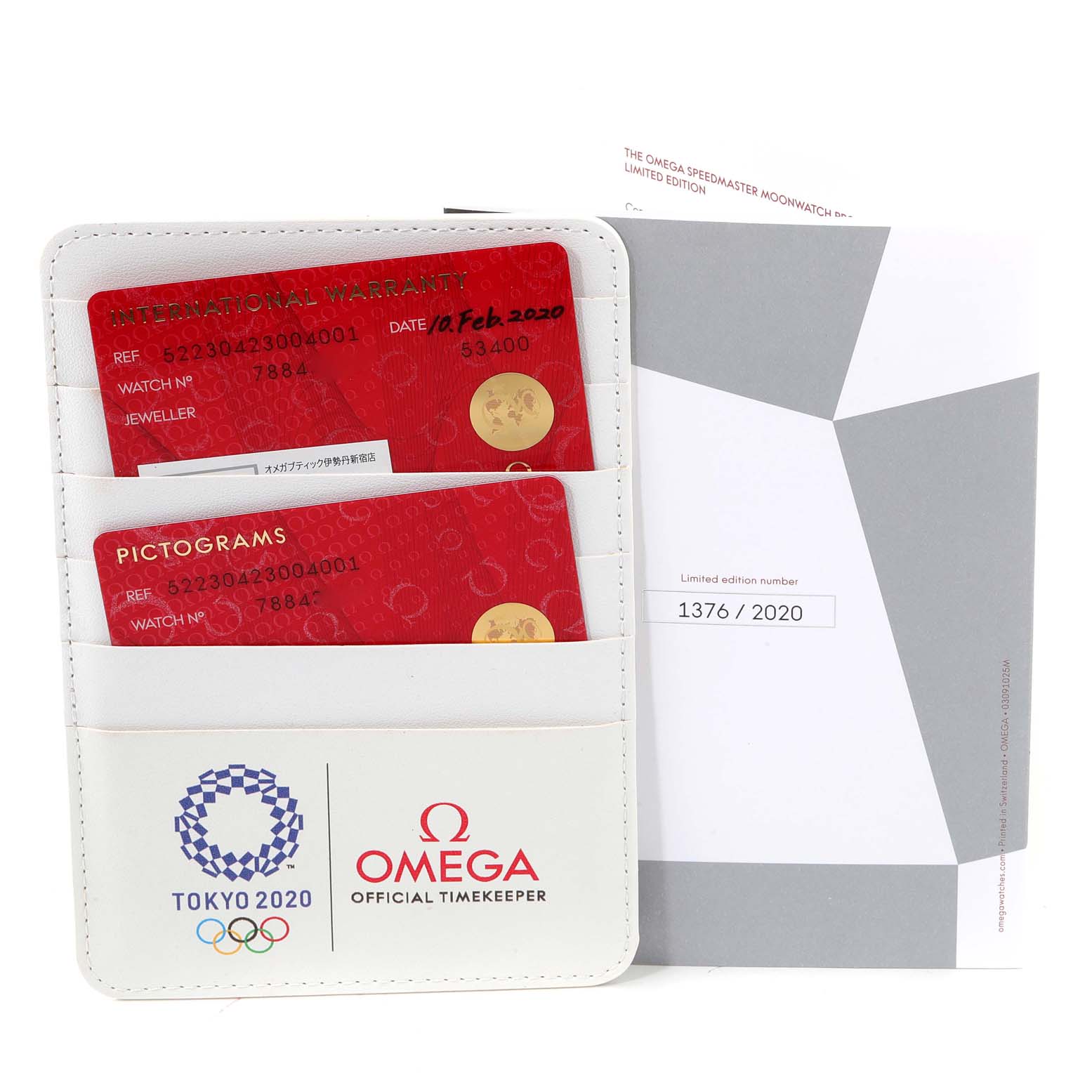 The image shows warranty cards and documentation for the Omega Speedmaster 522.30.42.30.04.001 Men's Stainless Steel White Dial 522.30.42.30.04.001 Men's Stainless Steel White Dial, displayed in an Omega-branded holder with Tokyo 2020 branding.