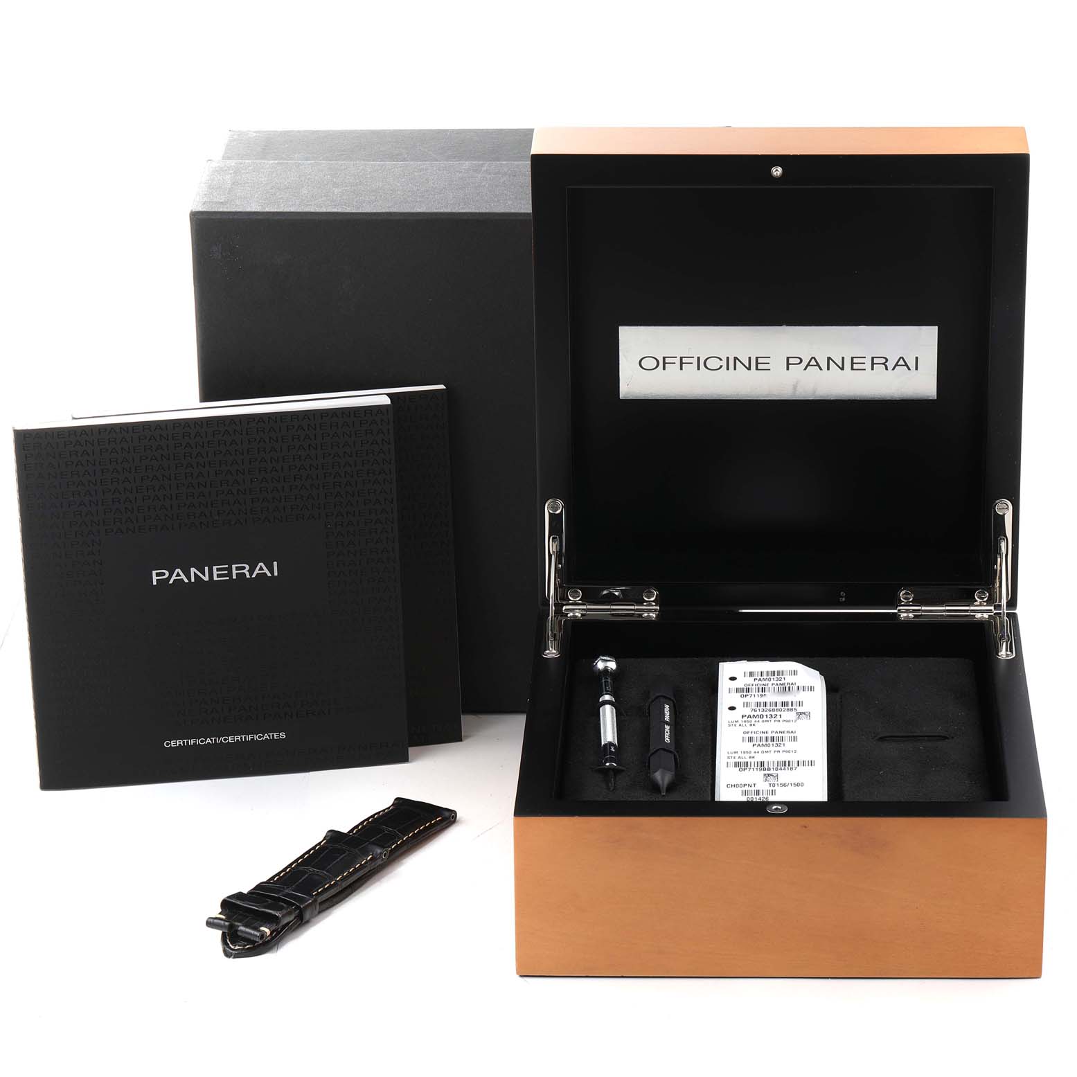 The image shows an angled view of a Panerai Luminor PAM01321 Men's Stainless Steel Black Dial PAM01321 Men's Stainless Steel Black Dial watch box with manuals, a tool, and an additional strap.