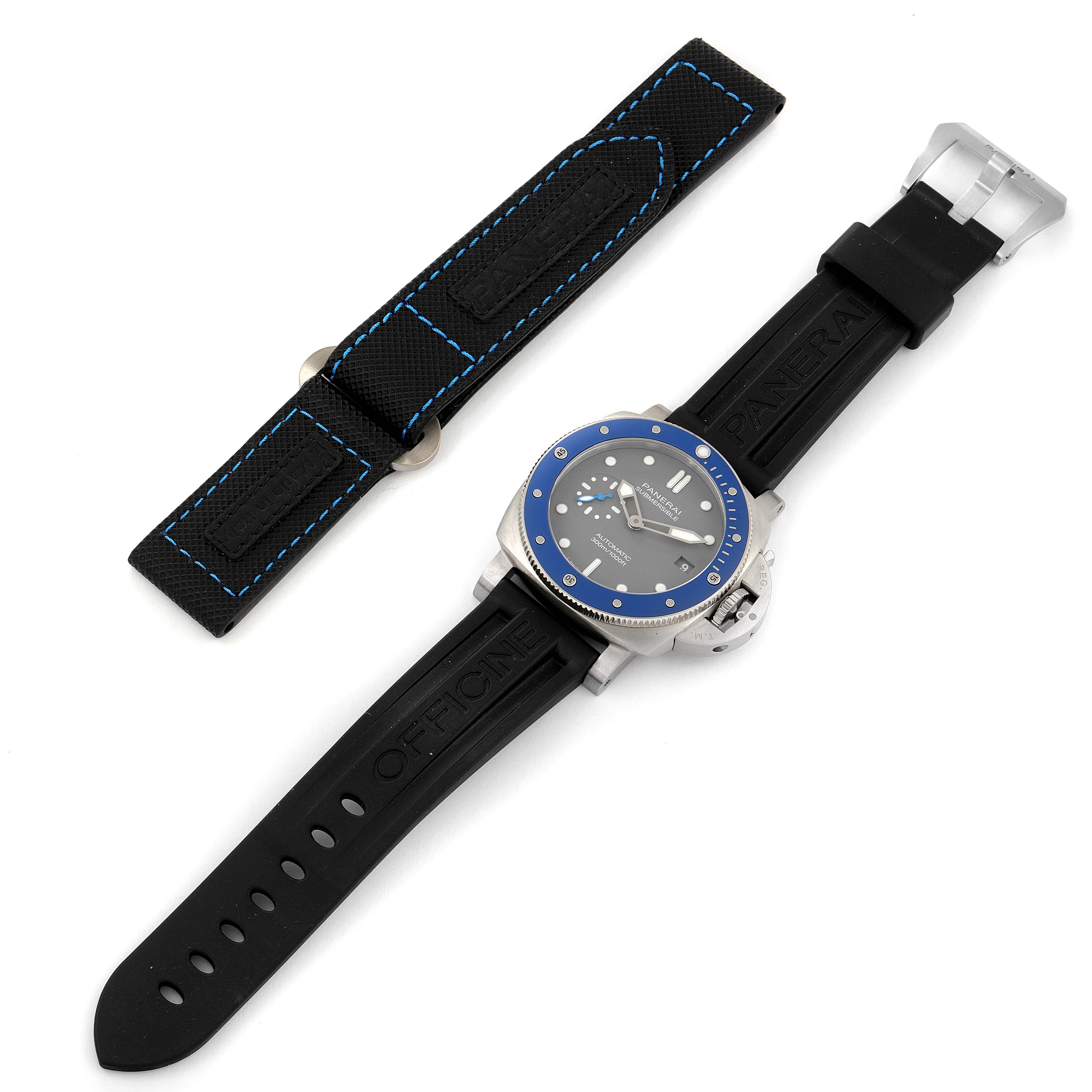 The image shows a Panerai Submersible PAM00959 Men's Stainless Steel Grey Dial PAM00959 Men's Stainless Steel Grey Dial watch with a black strap and an additional blue-stitched black strap from a top-down angle.