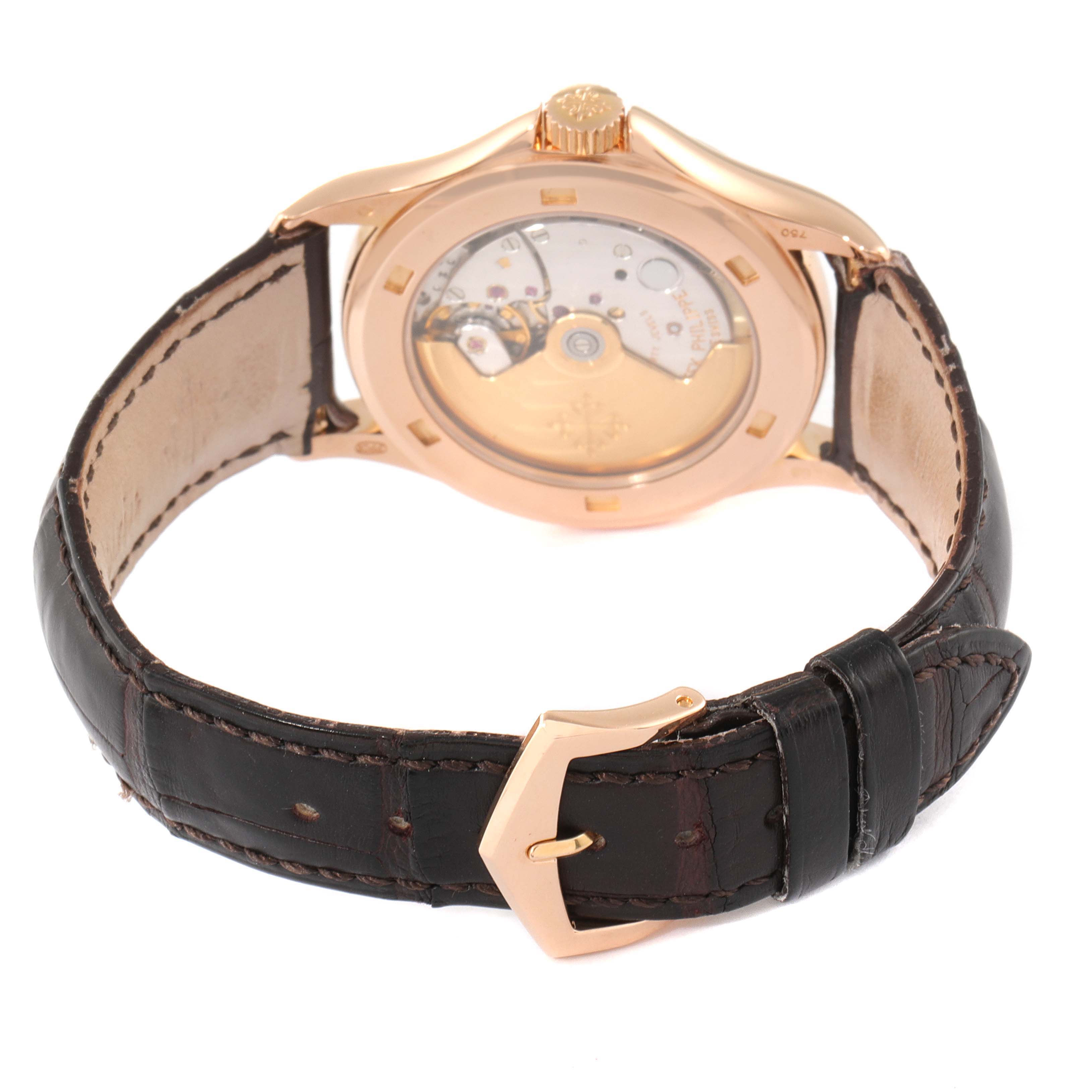 This image shows the back view of the Patek Philippe Calatrava 5107R-001 Men
s Rose Gold Silver Dial 5107R-001 Men
s Rose Gold Silver Dial watch with its mechanical movement visible and a leather strap.