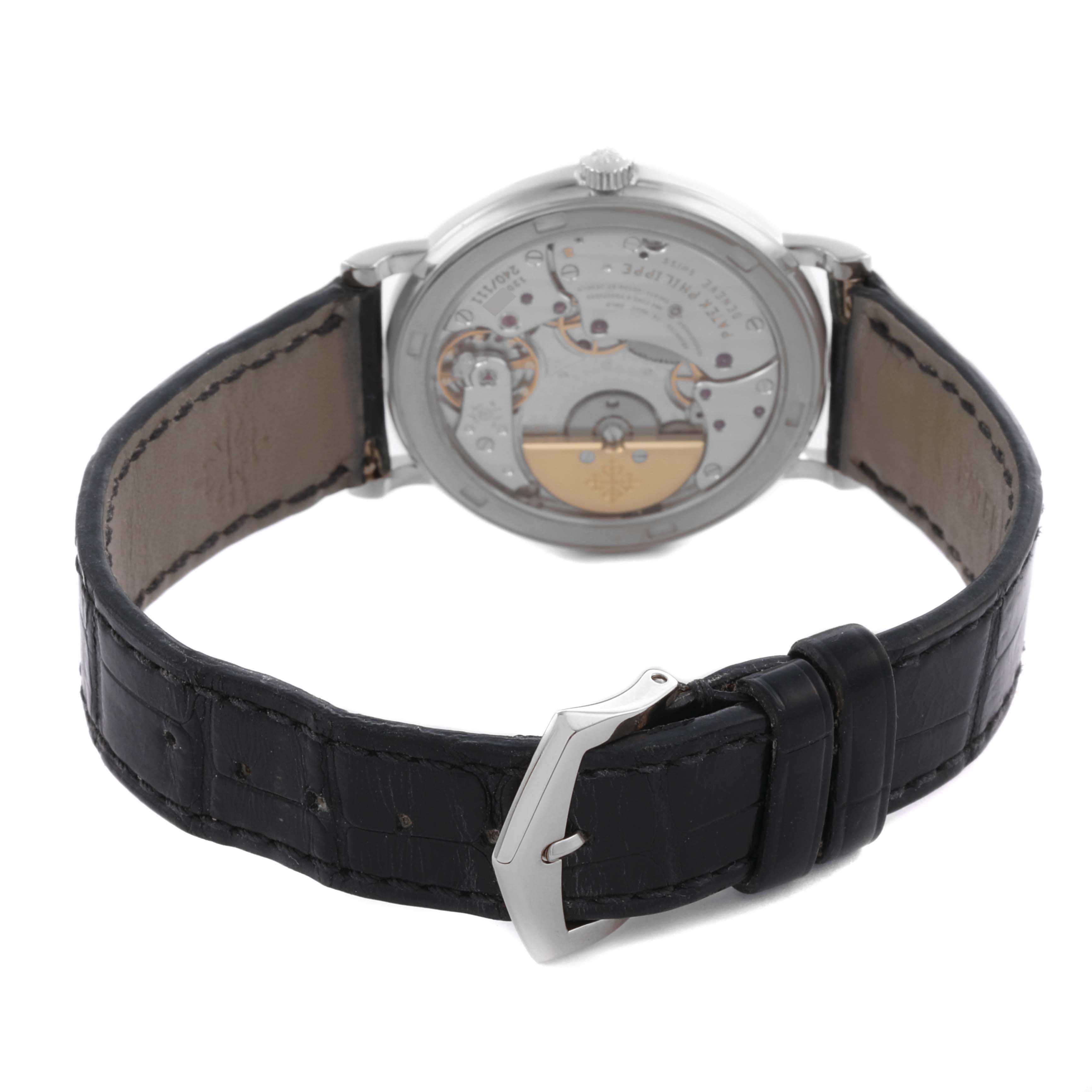 The image shows a Patek Philippe Calatrava 5120G Men's White Gold White Dial 5120G Men's White Gold White Dial watch from the back, highlighting the movement and leather strap with a buckle.