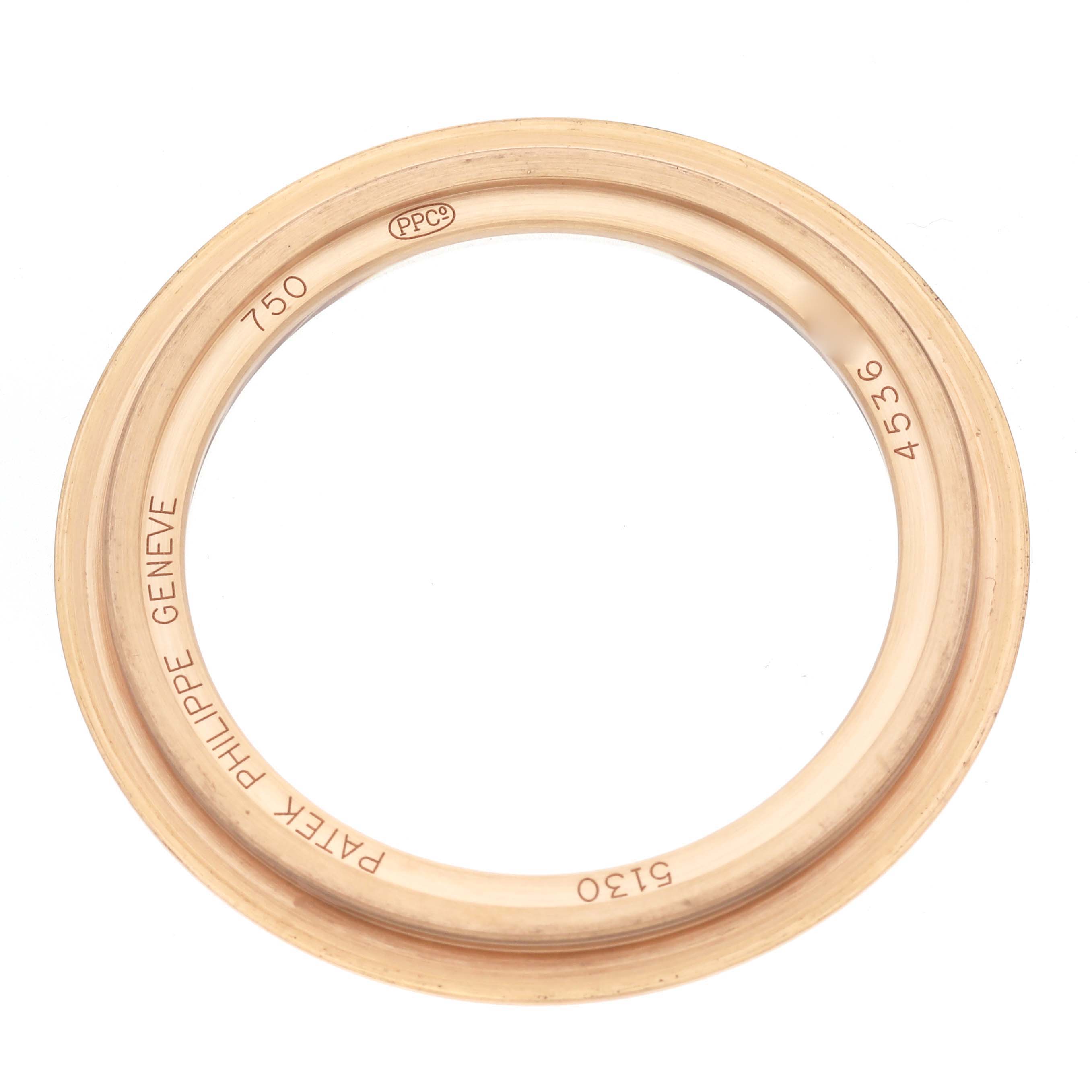 The image shows a bezel from the Patek Philippe Complications 5130R-018 Men
s Rose Gold Silver Dial 5130R-018 Men
s Rose Gold Silver Dial model viewed from above, displaying engravings and design details.