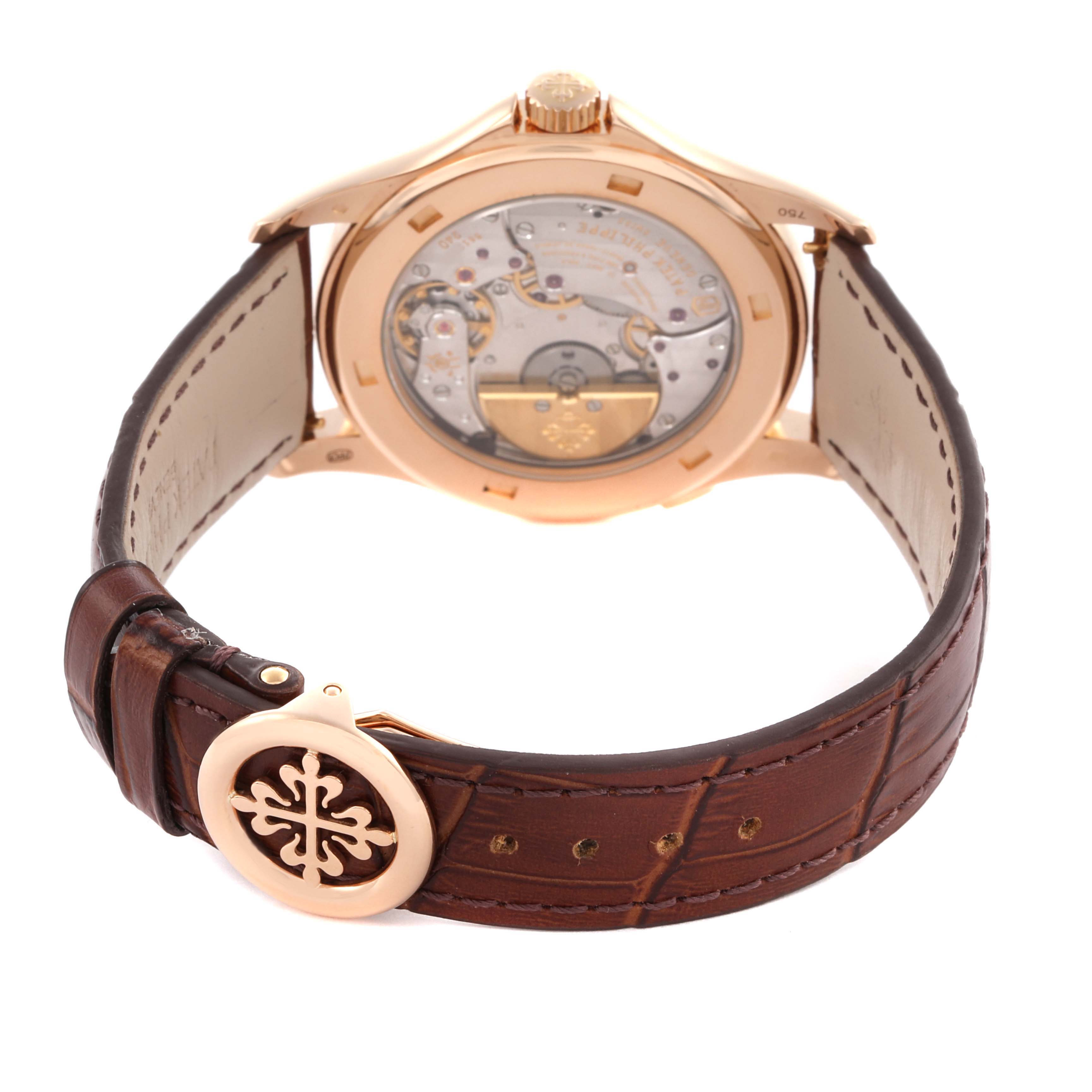 The image shows the back of a Patek Philippe Complications 5130R-018 Men
s Rose Gold Silver Dial 5130R-018 Men
s Rose Gold Silver Dial watch with its internal mechanism and brown leather strap.