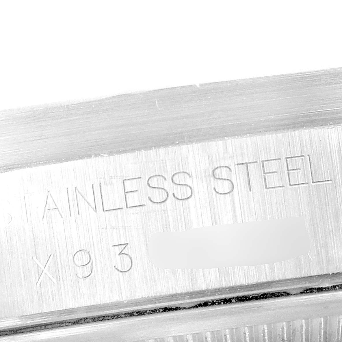 This image shows a close-up of the stainless steel casing with part of the serial number engraving of a Rolex Air-King 14010 Men's Stainless Steel Black Dial 14010 Men's Stainless Steel Black Dial watch.