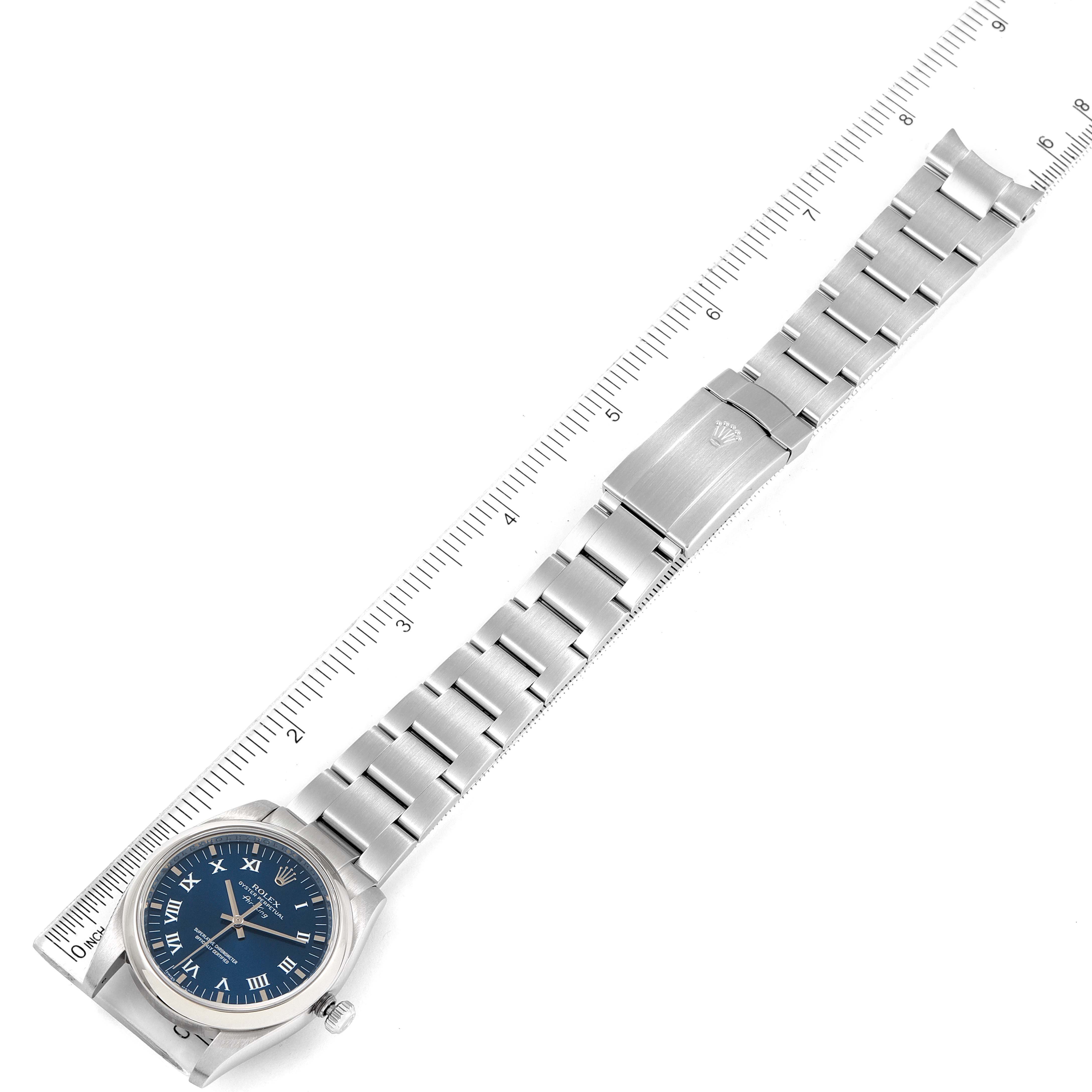 This image shows a top view of a Rolex Air-King 114200 Men's Stainless Steel Blue Dial 114200 Men's Stainless Steel Blue Dial watch, including the face, band, and clasp, with a ruler for scale.