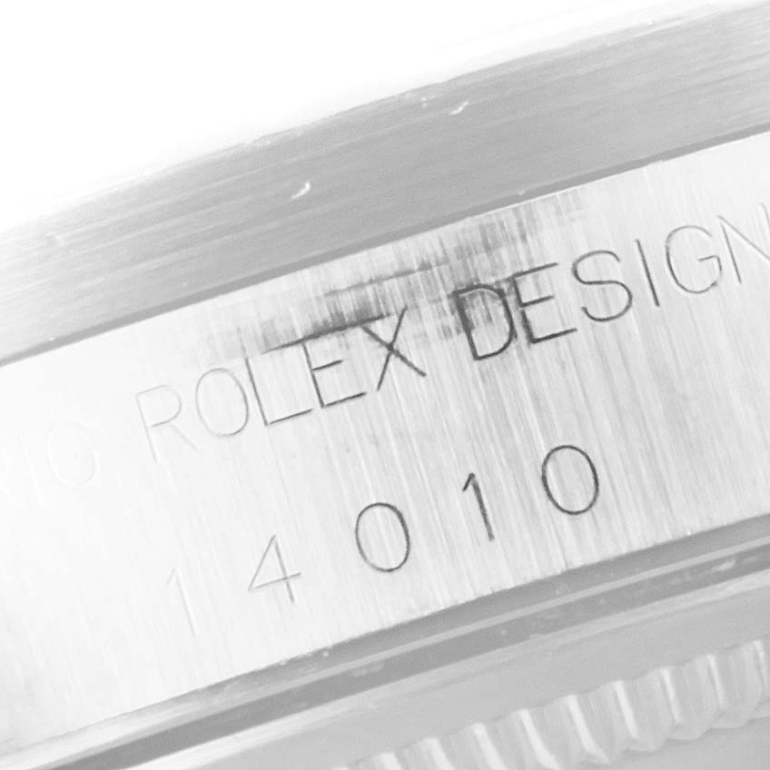 This close-up image shows the engraved serial number and "Rolex Design" on the case of a Rolex Air-King 14010 Men's Stainless Steel Blue Dial 14010 Men's Stainless Steel Blue Dial watch.