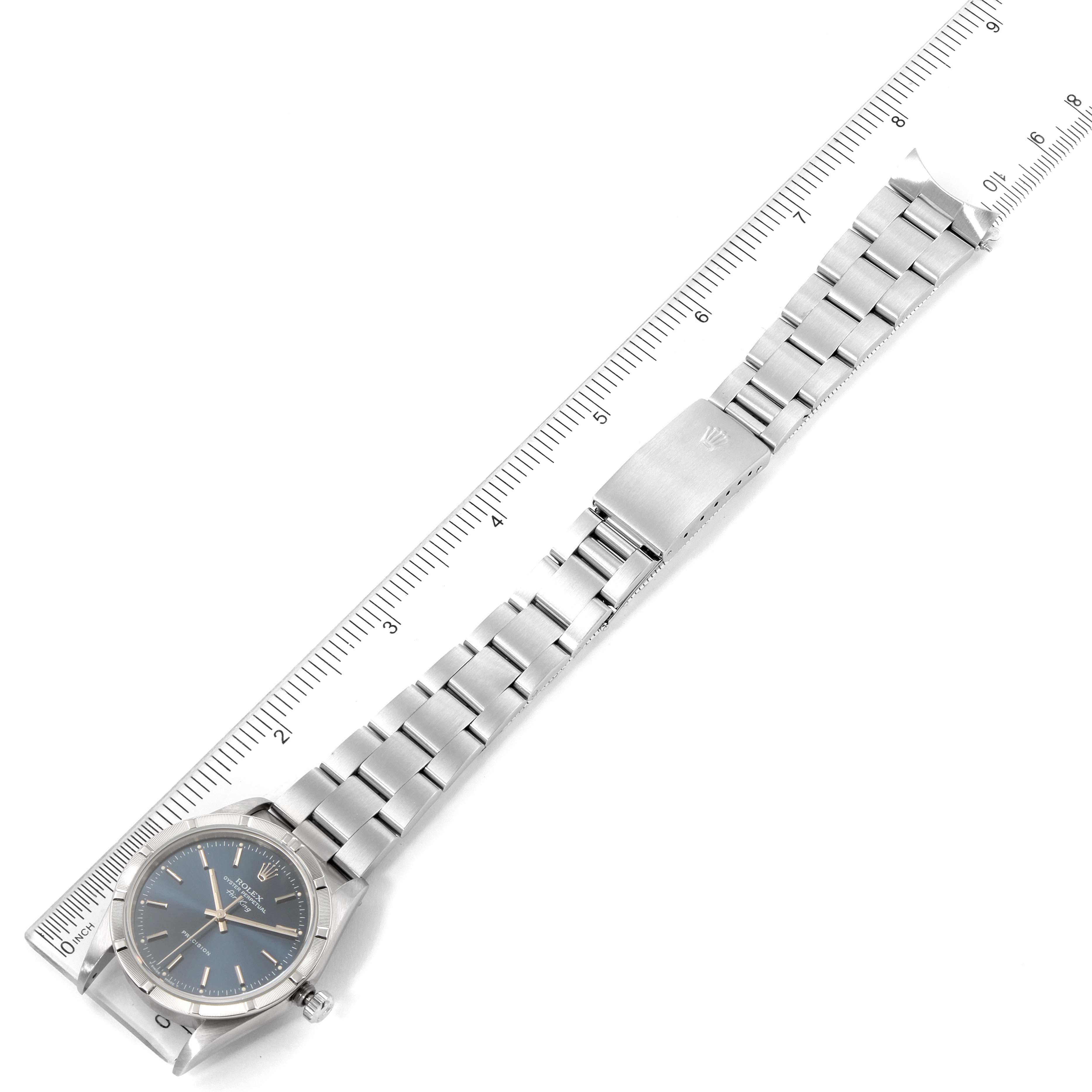This image shows a top view of a Rolex Air-King 14010 Men's Stainless Steel Blue Dial 14010 Men's Stainless Steel Blue Dial watch with its bracelet extended alongside a ruler for scale.