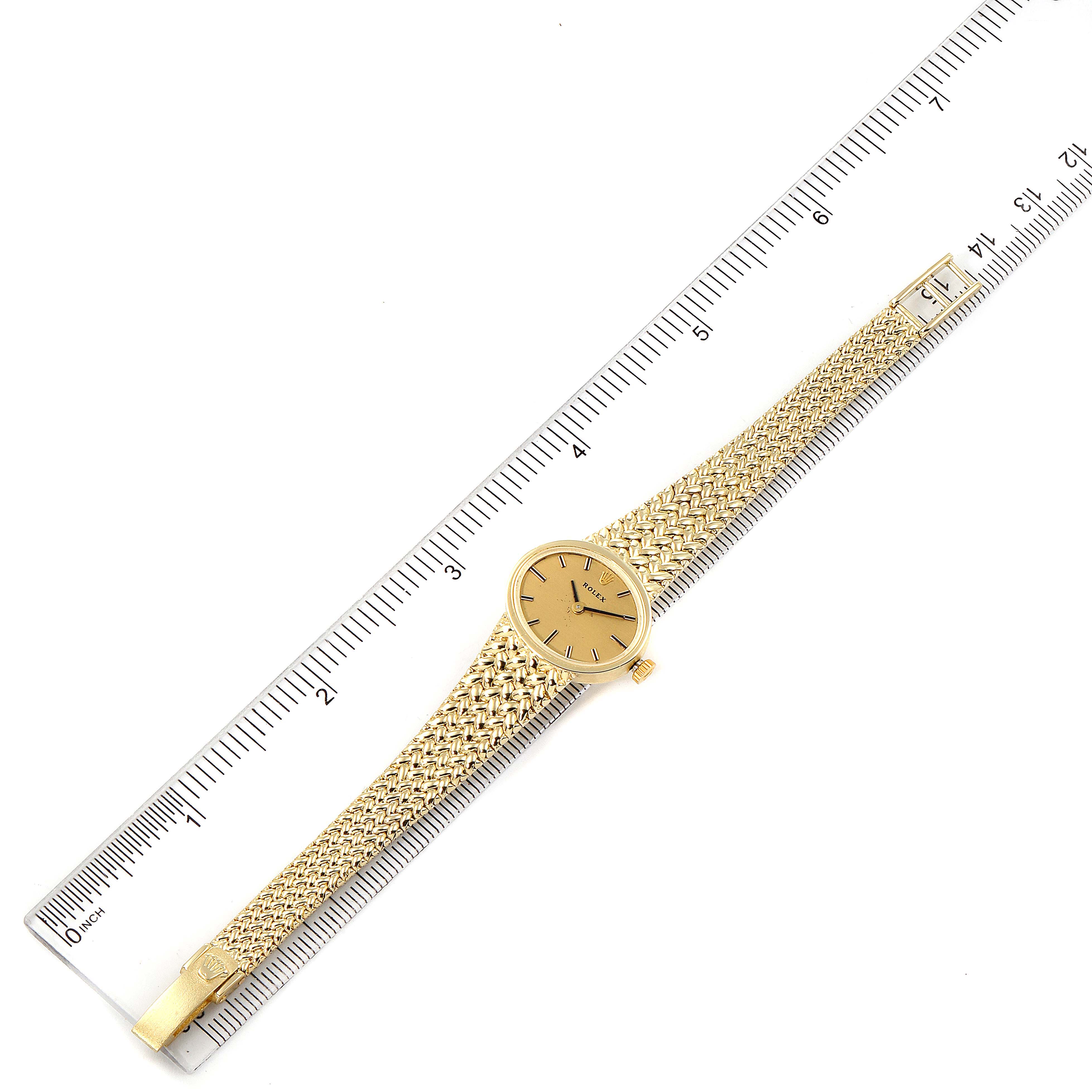 The Rolex Cocktail  Women
s Yellow Gold Champagne Dial  Women
s Yellow Gold Champagne Dial model watch is shown from the top, fully extended, with its dial, band, and clasp visible alongside a ruler.