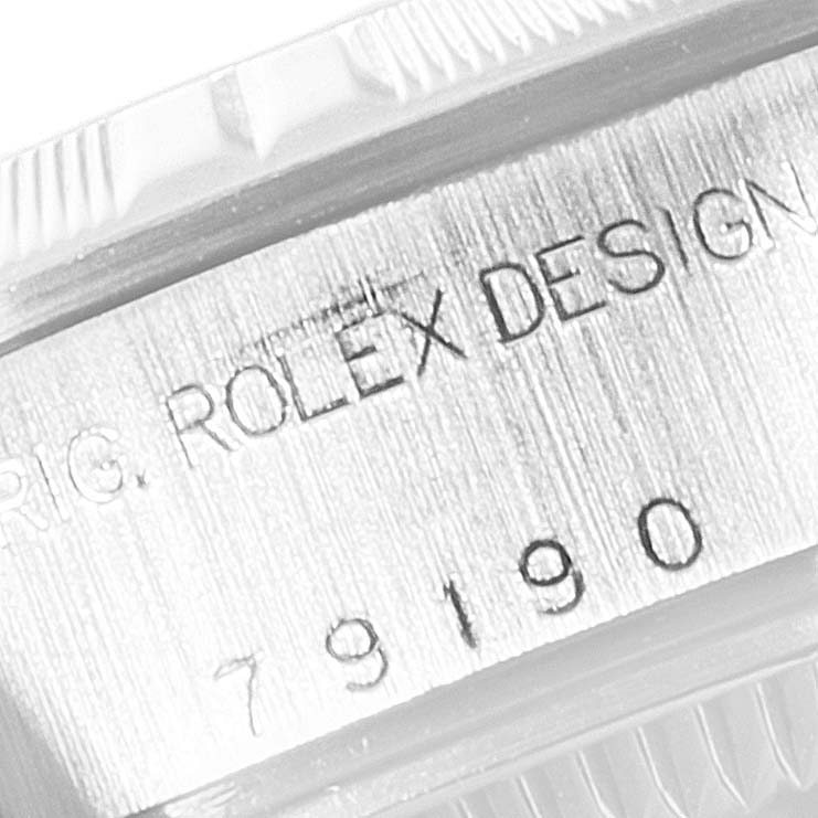 The image shows a close-up of the engraved text on the casing of a Rolex Date 79190 Women's Stainless Steel Black Dial 79190 Women's Stainless Steel Black Dial model watch.