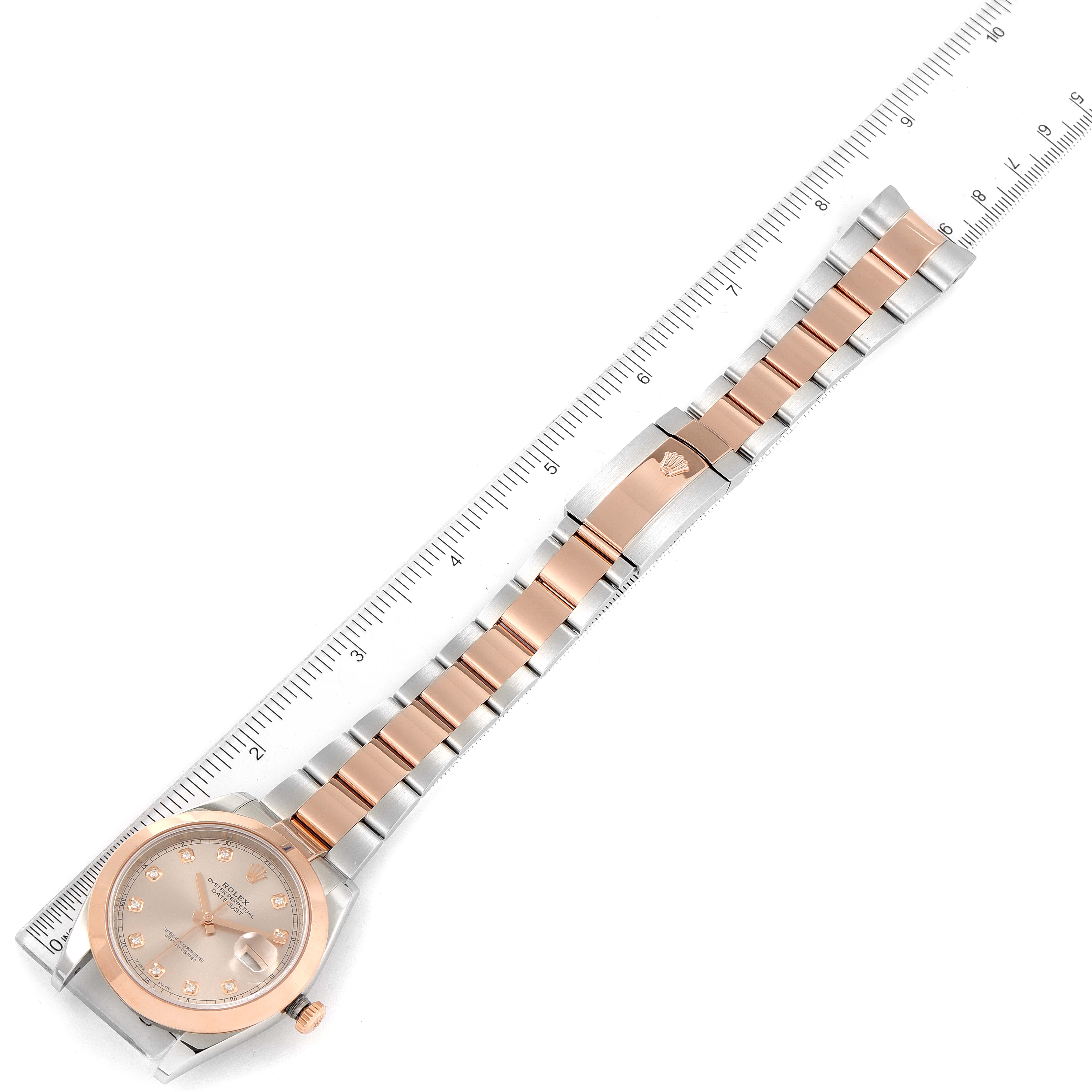 The Rolex Datejust 41 126301 Men's Steel and Gold (two tone) Pink Dial 126301 Men's Steel and Gold (two tone) Pink Dial watch is shown laid flat with the face and entire two-tone bracelet visible, next to a ruler for scale.