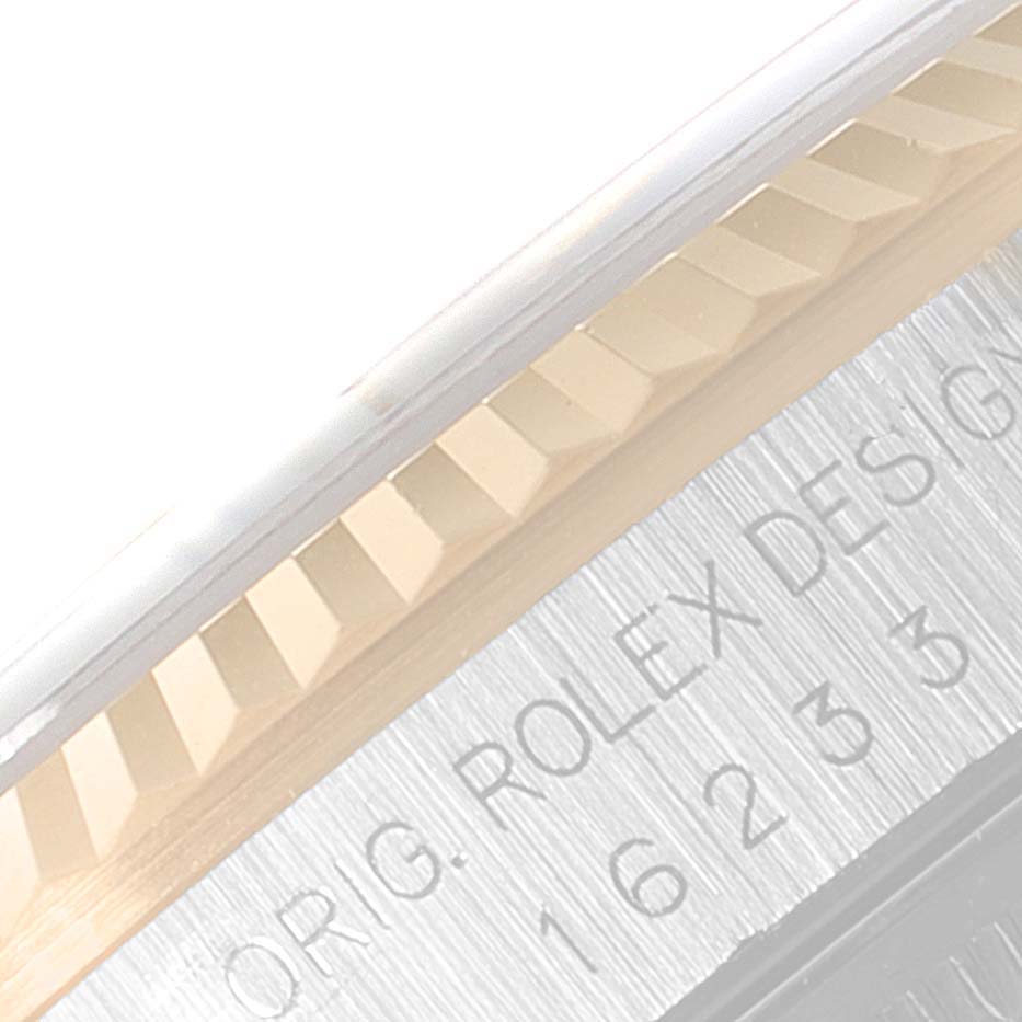 This image shows a close-up of the fluted bezel and part of the engraved case of the Rolex Datejust 16233 Men's Steel and Gold (two tone) Blue Dial 16233 Men's Steel and Gold (two tone) Blue Dial.