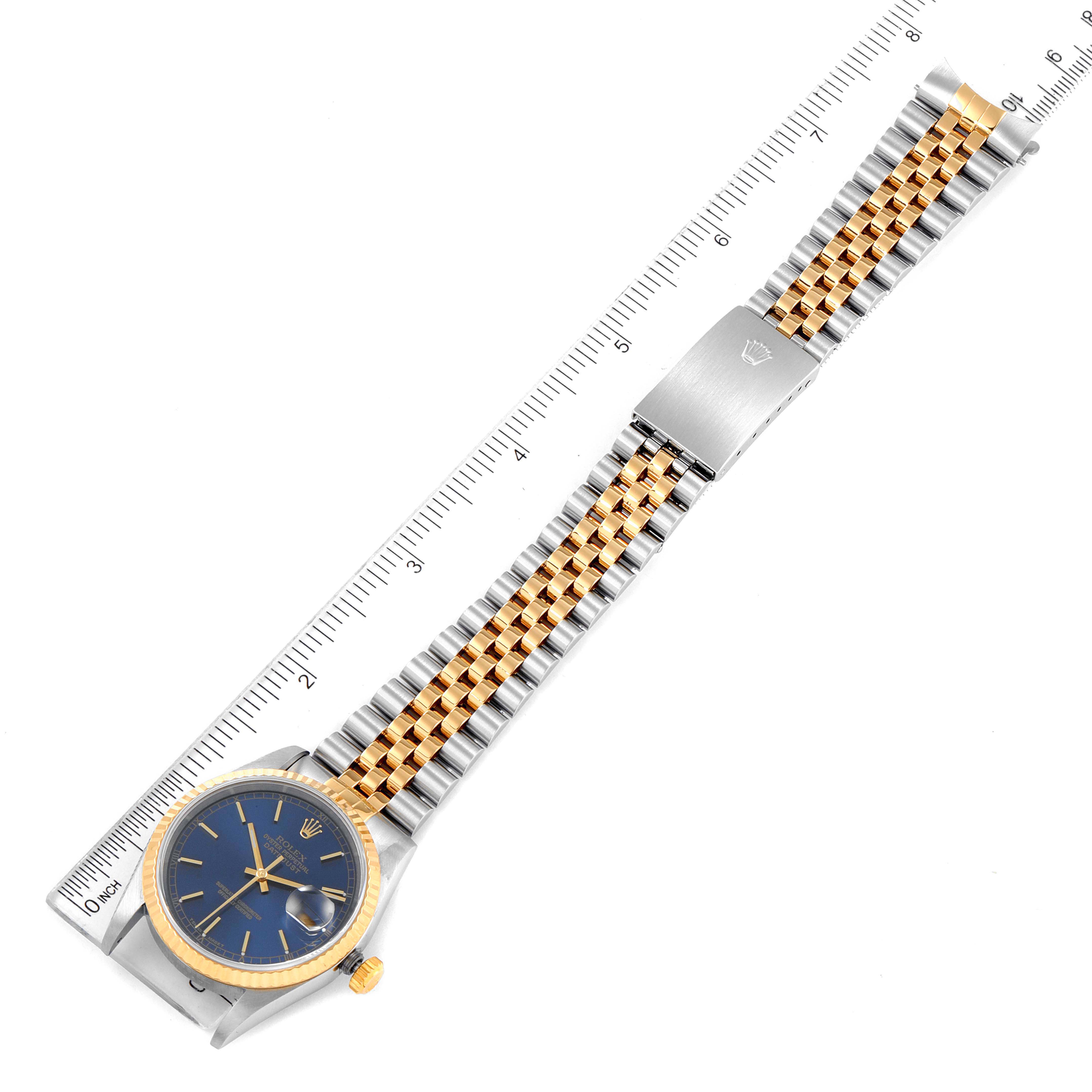 The Rolex Datejust 16233 Men's Steel and Gold (two tone) Blue Dial 16233 Men's Steel and Gold (two tone) Blue Dial watch is shown from a top-down angle, displaying the dial, crown, and bracelet with a ruler for scale.