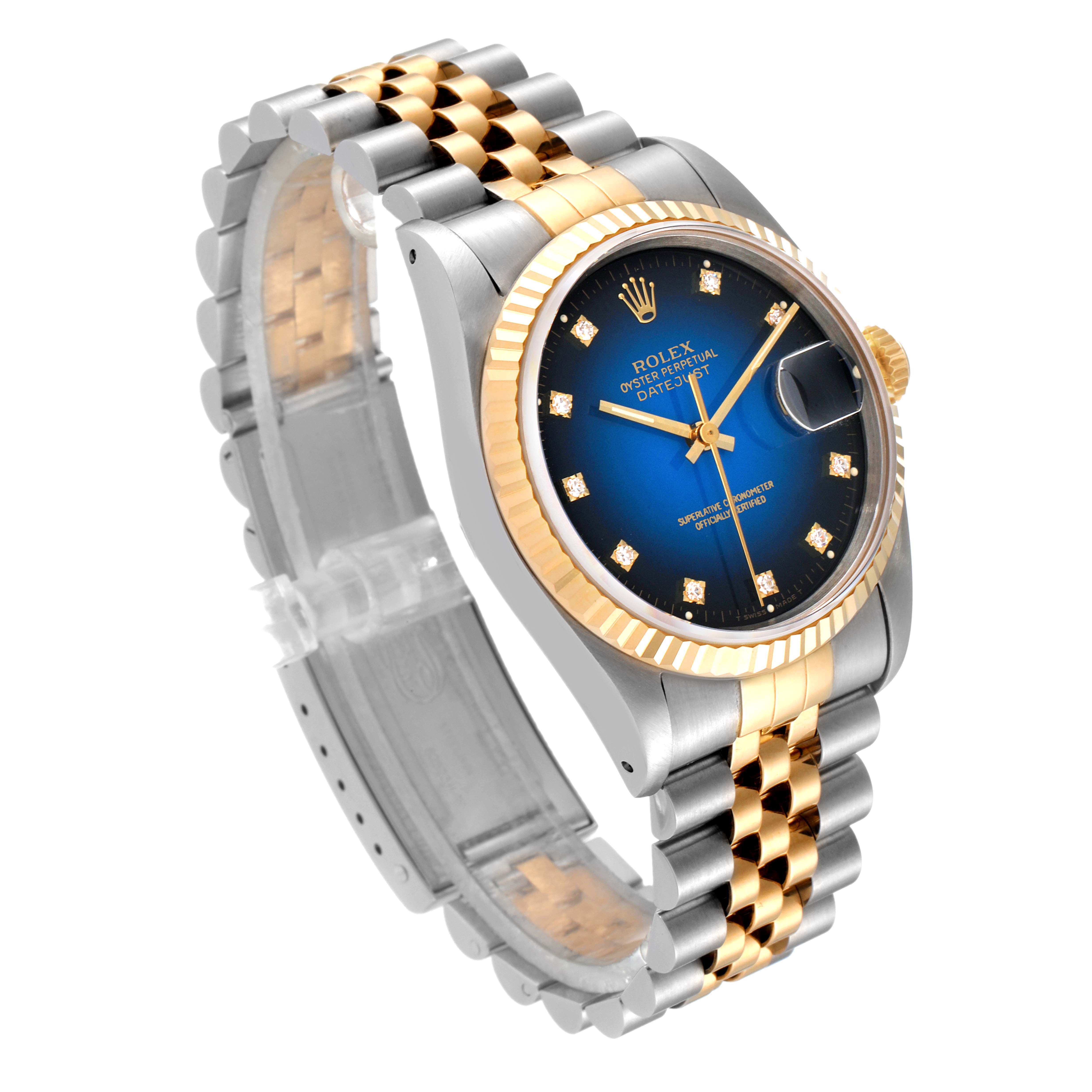 The image shows a Rolex Datejust 16233 Men's Steel and Gold (two tone) Blue Dial 16233 Men's Steel and Gold (two tone) Blue Dial watch at an angle showcasing its bracelet, dial, fluted bezel, and crown.
