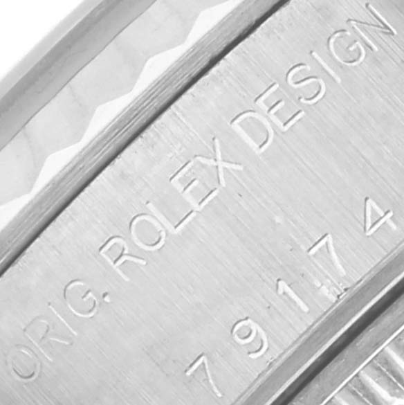 The image shows an angled close-up of the Rolex Datejust 79174 Women's Stainless Steel Pink Dial 79174 Women's Stainless Steel Pink Dial's case with engraved model details.