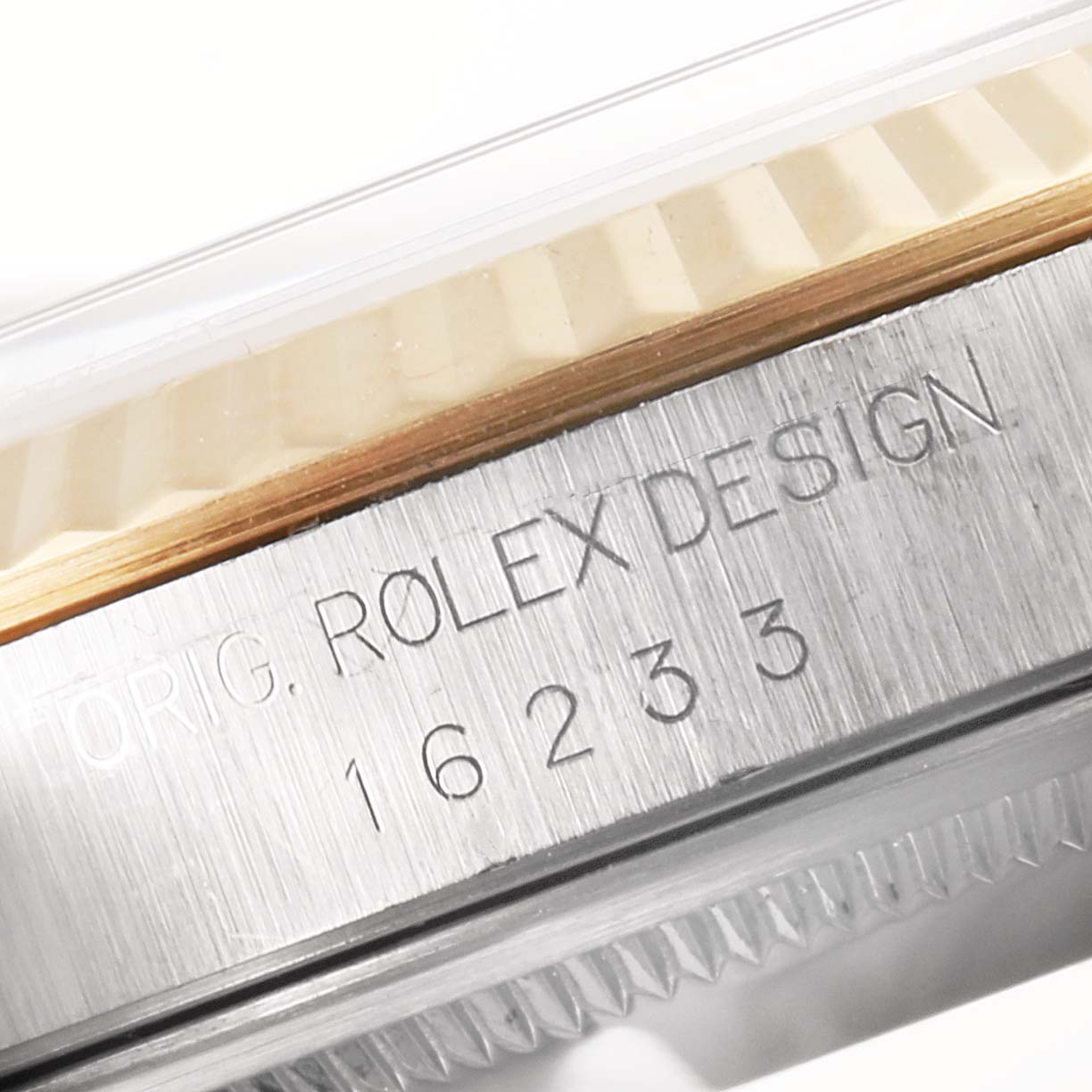This close-up image shows the side of a Rolex Datejust 16233 Men's Steel and Gold (two tone) Black Dial 16233 Men's Steel and Gold (two tone) Black Dial model's case with its engraved model number "16233."