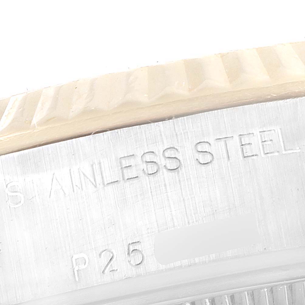 This close-up image of the Rolex Datejust 79173 Women's Steel and Gold (two tone) Blue Dial 79173 Women's Steel and Gold (two tone) Blue Dial shows the engraved stainless steel case and a portion of the fluted bezel.