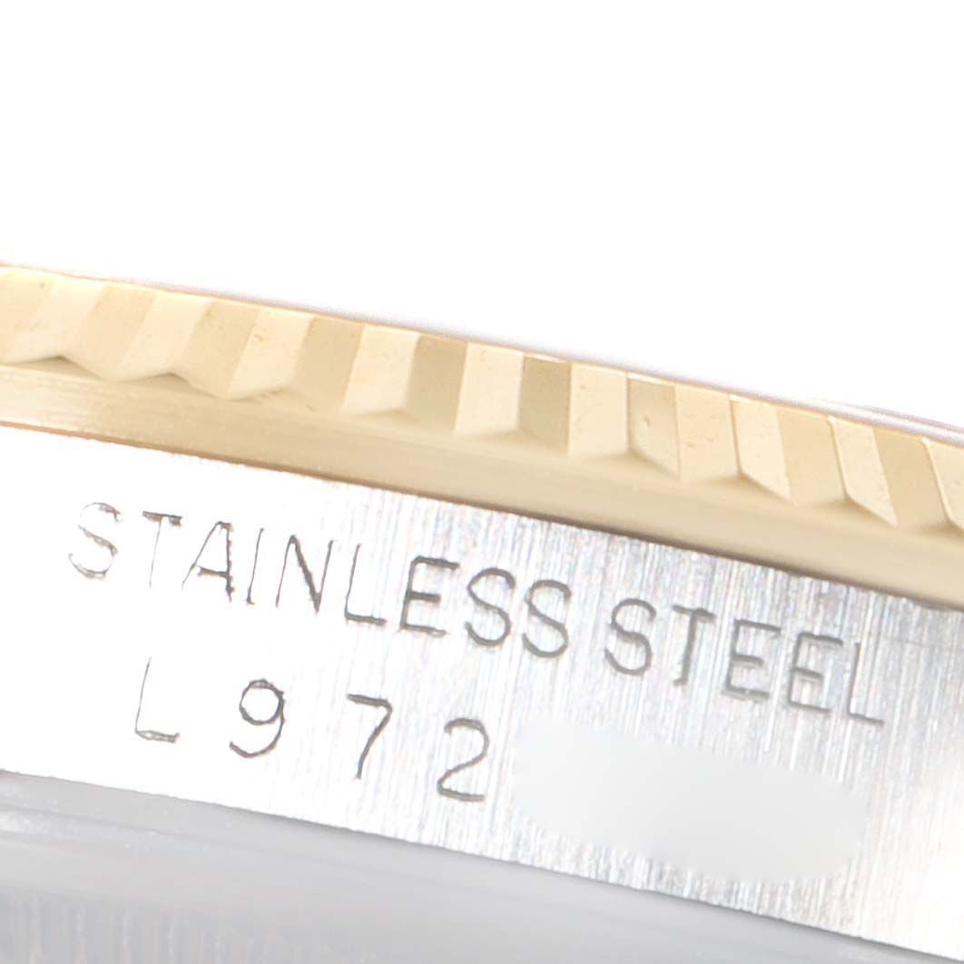 The image shows a close-up of the side of a Rolex Datejust 16233 Men's Steel and Gold (two tone) Champagne Dial 16233 Men's Steel and Gold (two tone) Champagne Dial watch, highlighting the fluted bezel and part of the case with "STAINLESS STEEL" engraving.