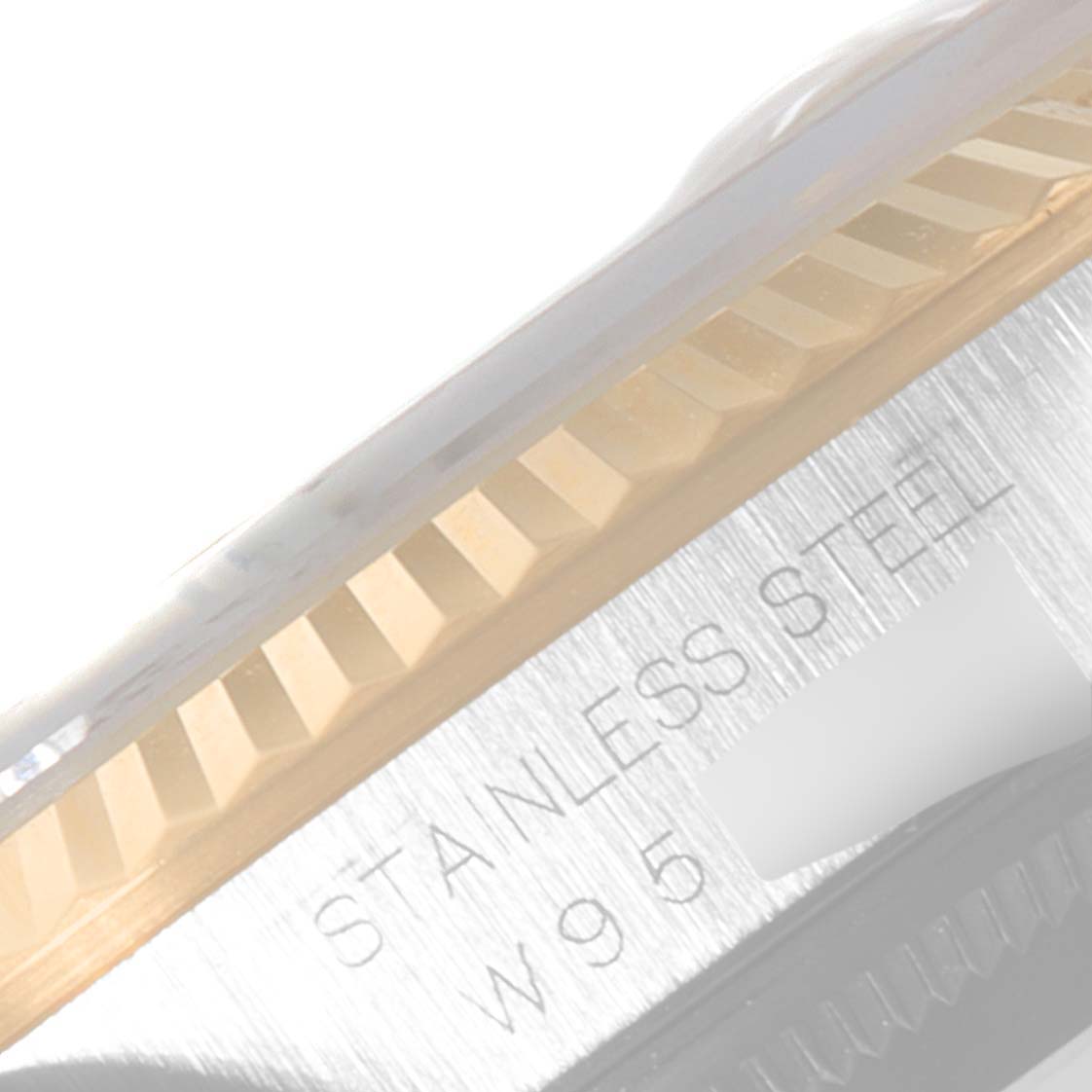 This image shows a close-up of the fluted bezel and edge of the case back of a Rolex Datejust 16233 Men
s Steel and Gold (two tone) Champagne Dial 16233 Men
s Steel and Gold (two tone) Champagne Dial model, indicating stainless steel with the engraving "STANLESS STEEL".