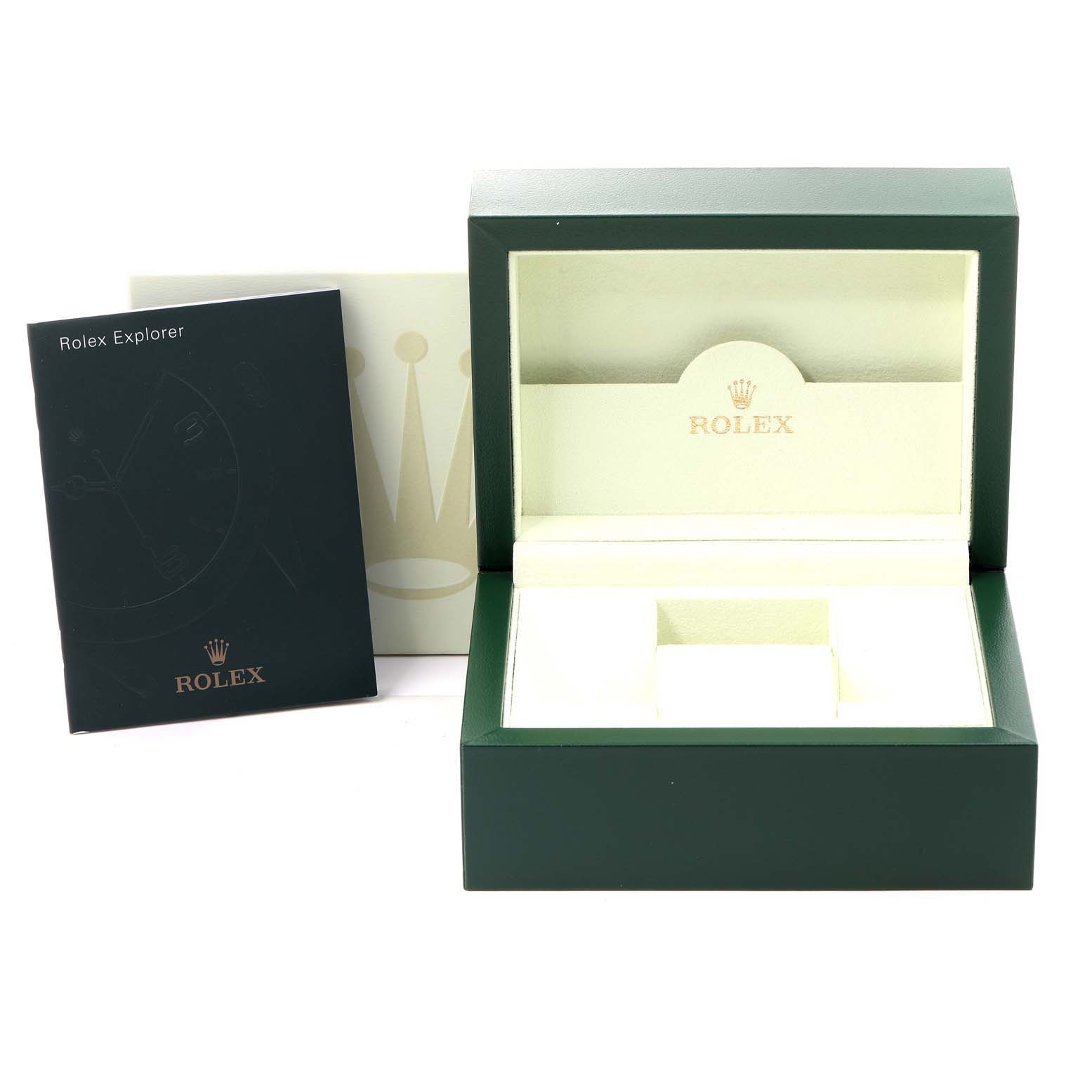 The image shows an open green Rolex watch box with an Explorer model booklet next to it.