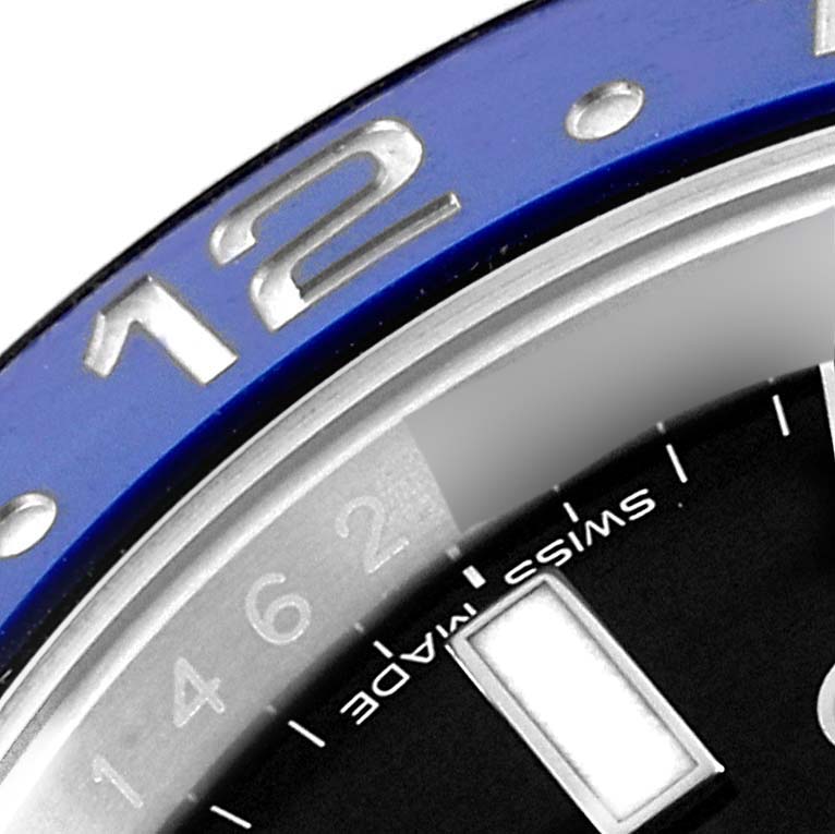 The image shows a close-up angle of the bezel and a portion of the dial on a Rolex GMT-Master 116710 Men's Stainless Steel Black Dial 116710 Men's Stainless Steel Black Dial watch, highlighting the "12" on the bezel and "Swiss Made" on the dial.