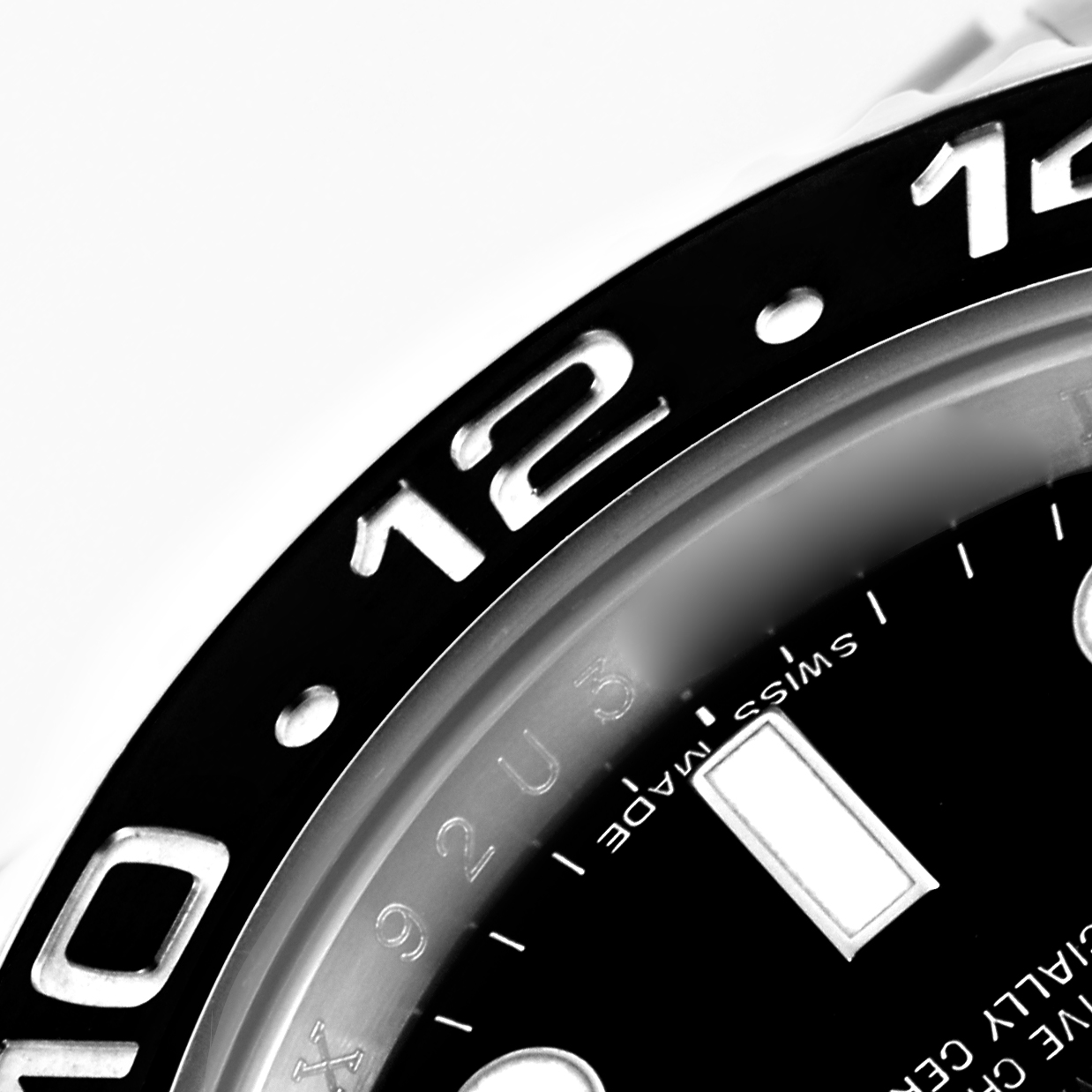 The image shows a close-up of the Rolex GMT-Master 116710LN Men's Stainless Steel Black Dial 116710LN Men's Stainless Steel Black Dial's bezel and part of the dial, highlighting the "12" marker.