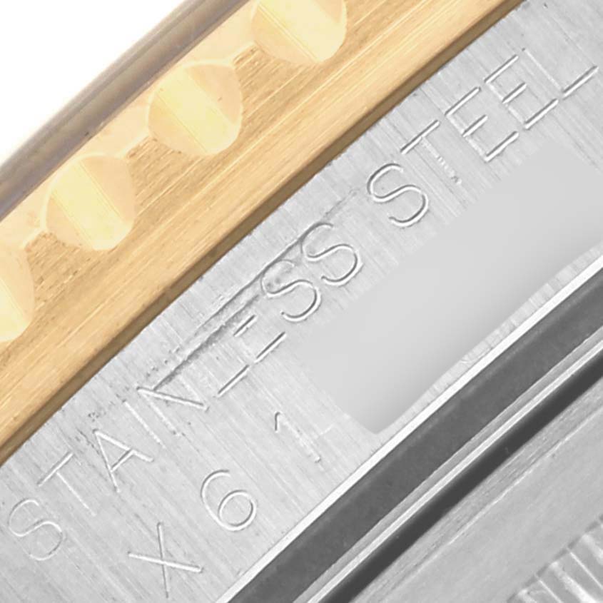 The image shows a close-up of the Rolex GMT-Master 16713 Men's Steel and Gold (two tone) Black Dial 16713 Men's Steel and Gold (two tone) Black Dial's gold and stainless steel bracelet, displaying engraved details.