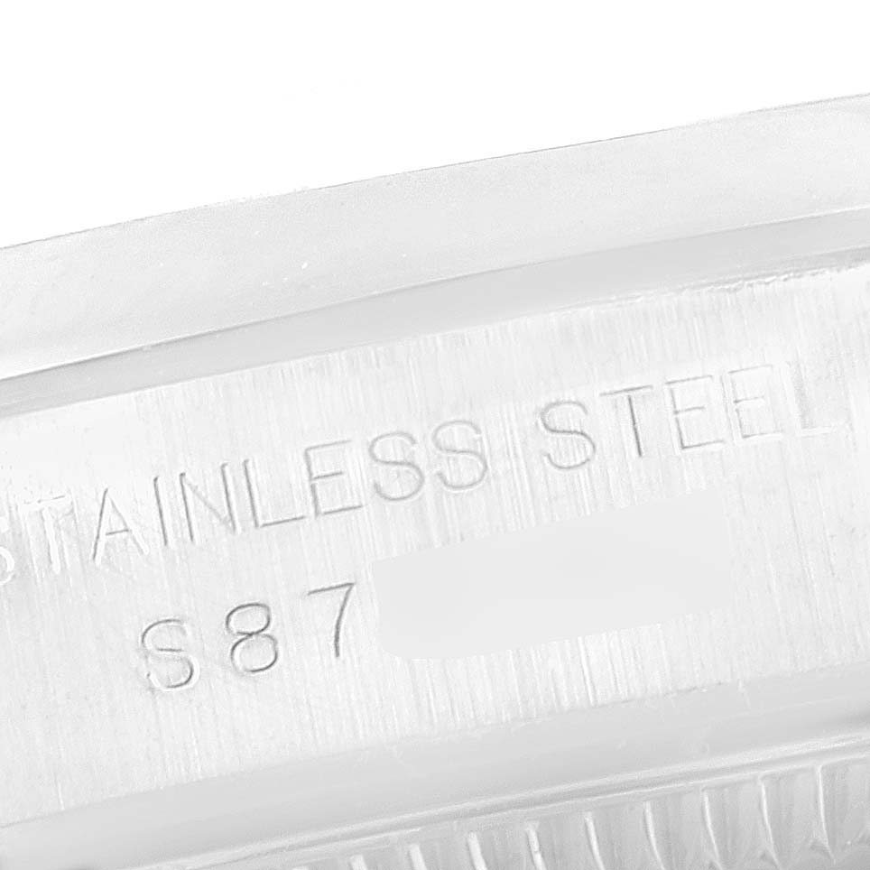 This is a close-up view of the side of a Rolex Oyster Perpetual 67180 Women
s Stainless Steel Blue Dial 67180 Women
s Stainless Steel Blue Dial watch, showing "STAINLESS STEEL" and the serial or model number "S87".