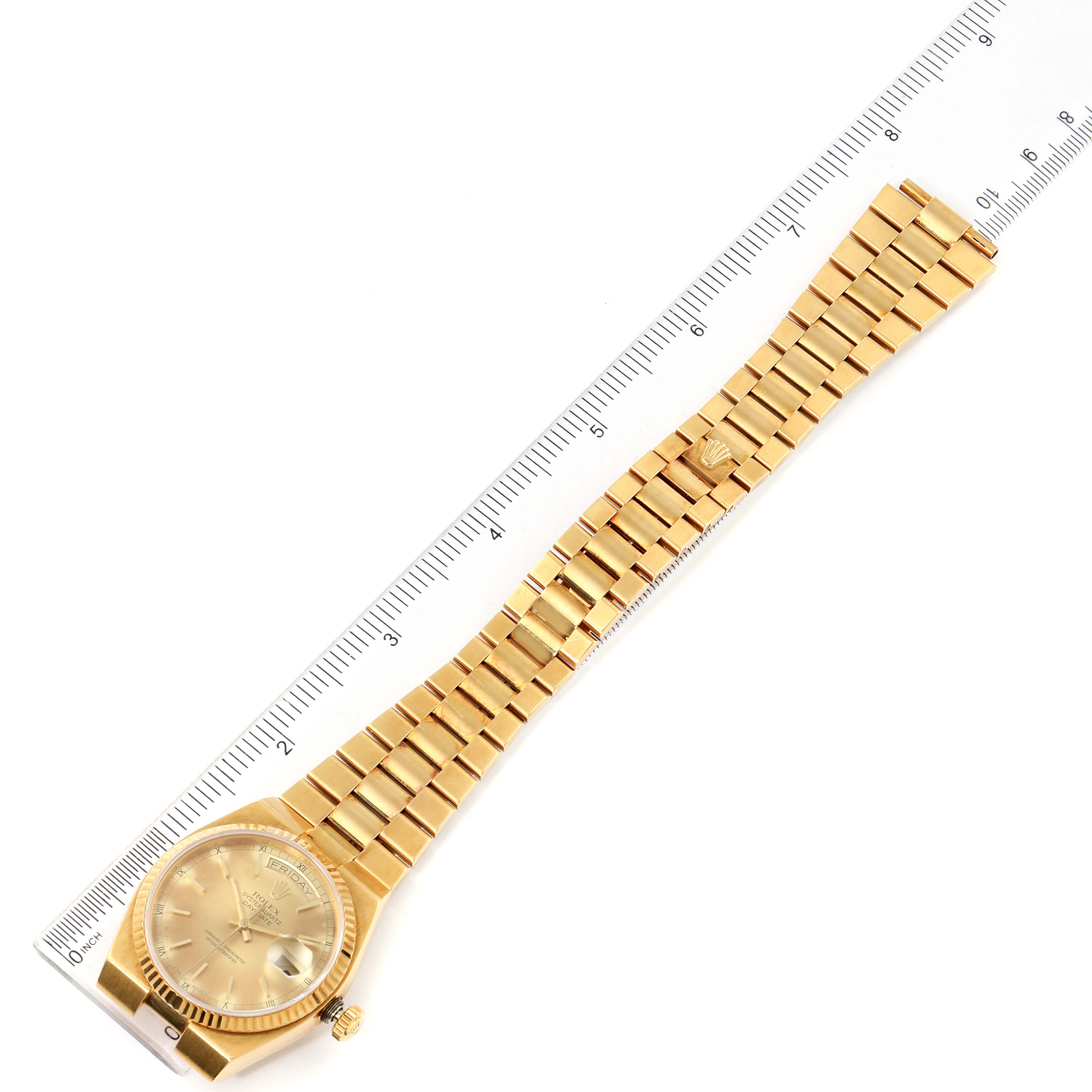 This image shows an overhead view of the Rolex Oysterquartz 19018 Men
s Yellow Gold Champagne Dial 19018 Men
s Yellow Gold Champagne Dial watch, displaying its bracelet and face, along with a ruler for scale.