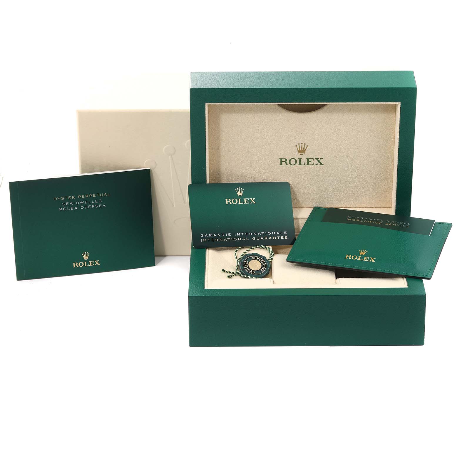 The image shows an open green Rolex box for the Sea-Dweller model, with booklets and a guarantee card displayed around it.