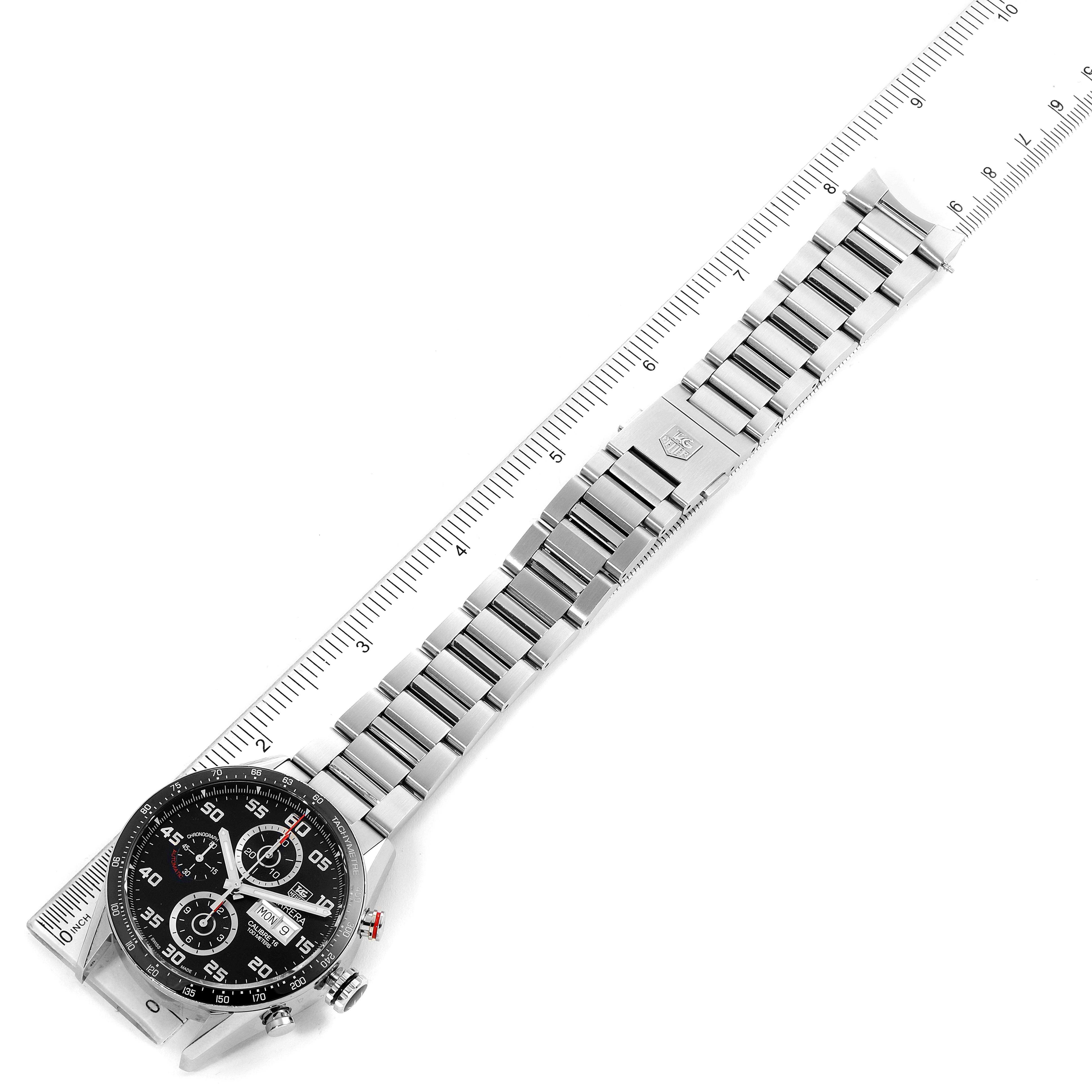 The image shows a top-view angle of a Tag Heuer Carrera CV2A1R.BA0799 Men
s Stainless Steel Black Dial CV2A1R.BA0799 Men
s Stainless Steel Black Dial watch, featuring the dial, bezel, bracelet, and clasp alongside a ruler.