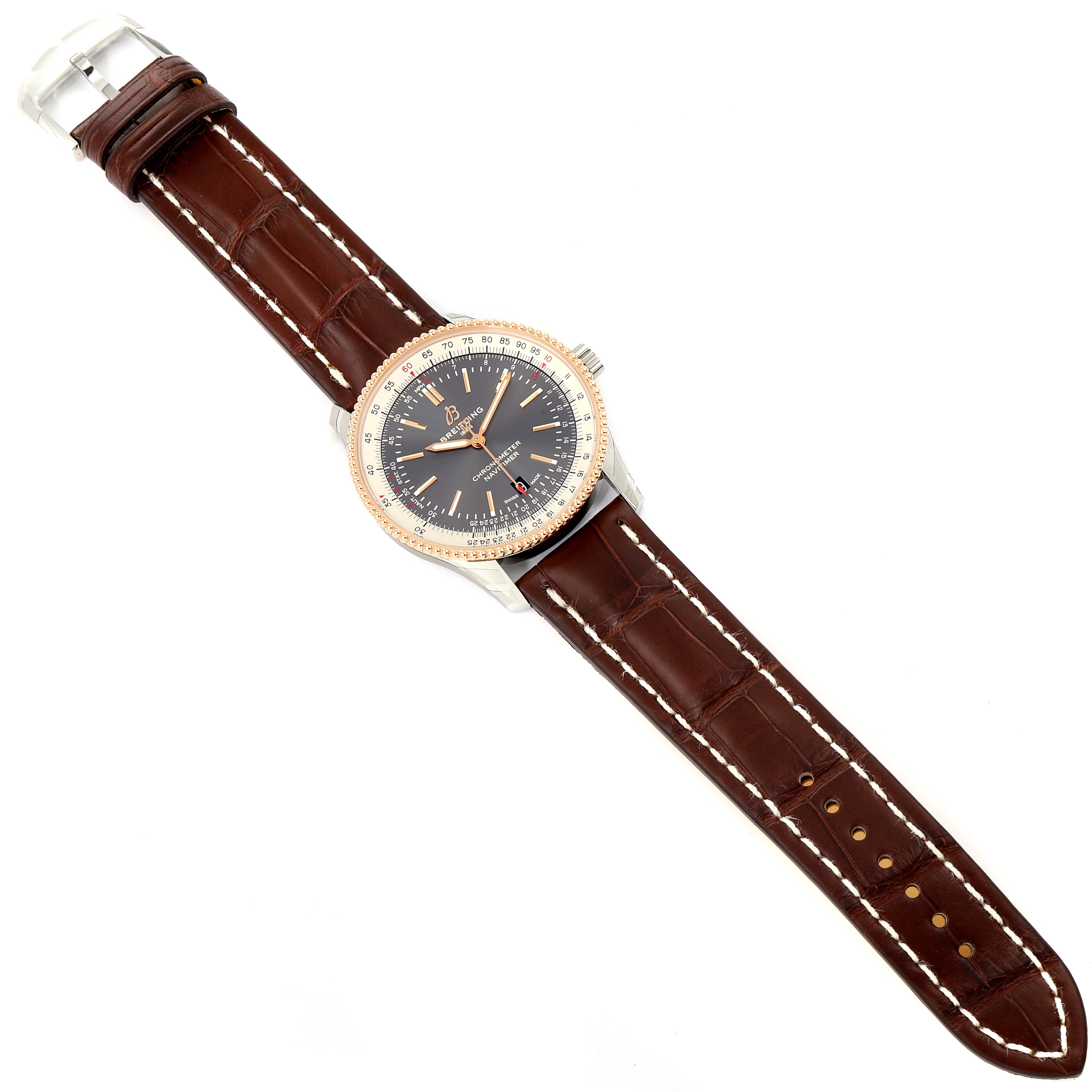 The image shows a top-down view of a Navitimer model watch by Breitling with a brown leather strap and a black dial.