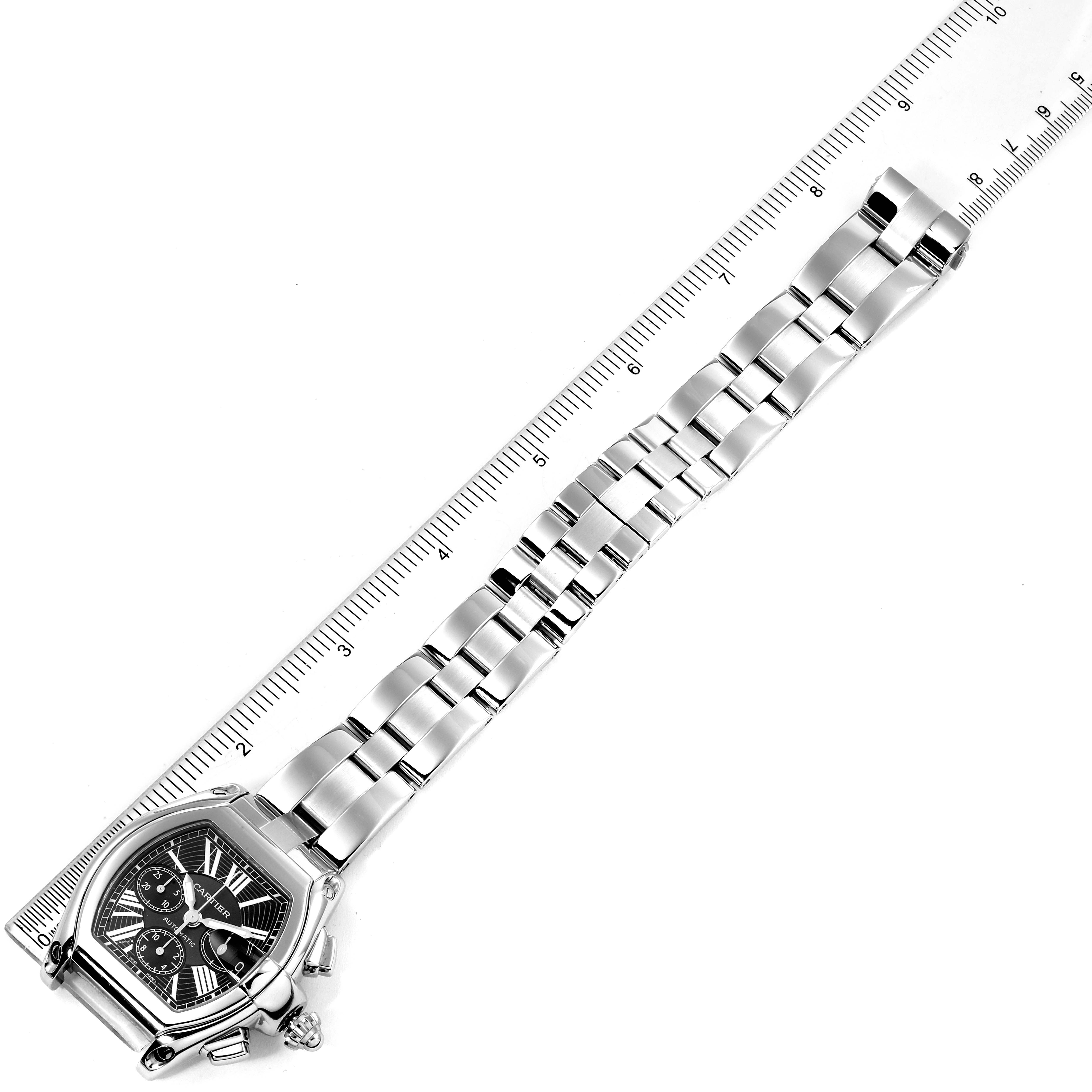 The image shows a top-down view of the Cartier Roadster W62020X6 Men
s Stainless Steel Black Dial W62020X6 Men
s Stainless Steel Black Dial model watch, displaying the face, bracelet, and a ruler for scale.