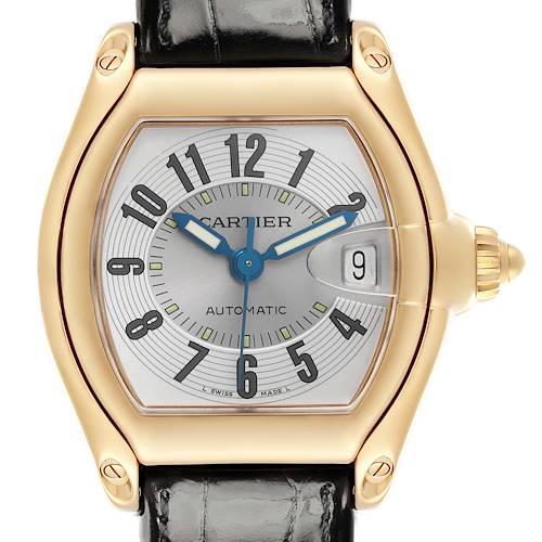 The Cartier Roadster watch is shown from a front angle, highlighting its face, gold casing, and black strap.