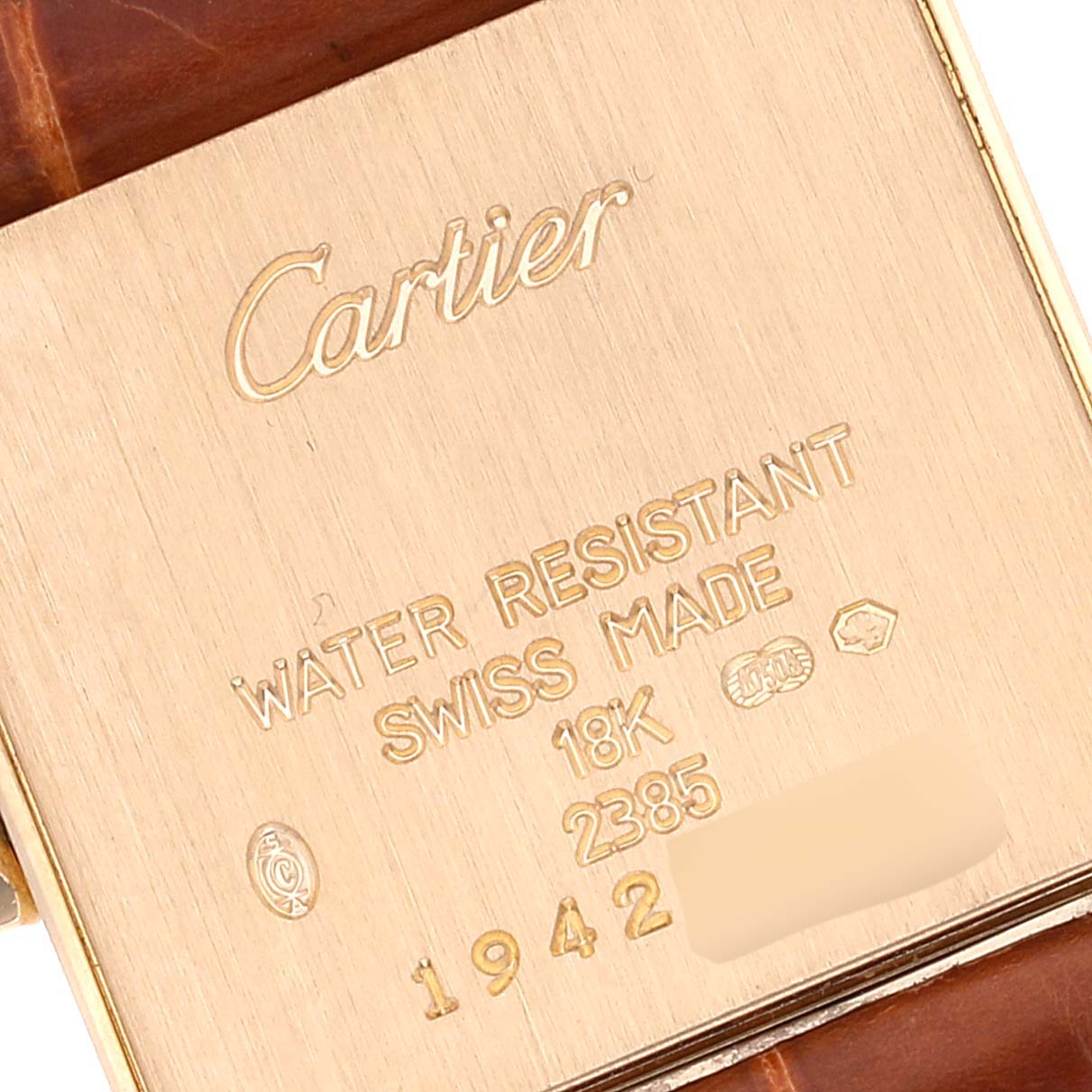 This image shows the engraved back of a Cartier Tank Francaise W5000256 Women's Yellow Gold Silver Dial W5000256 Women's Yellow Gold Silver Dial watch, displaying its specifications and serial number.