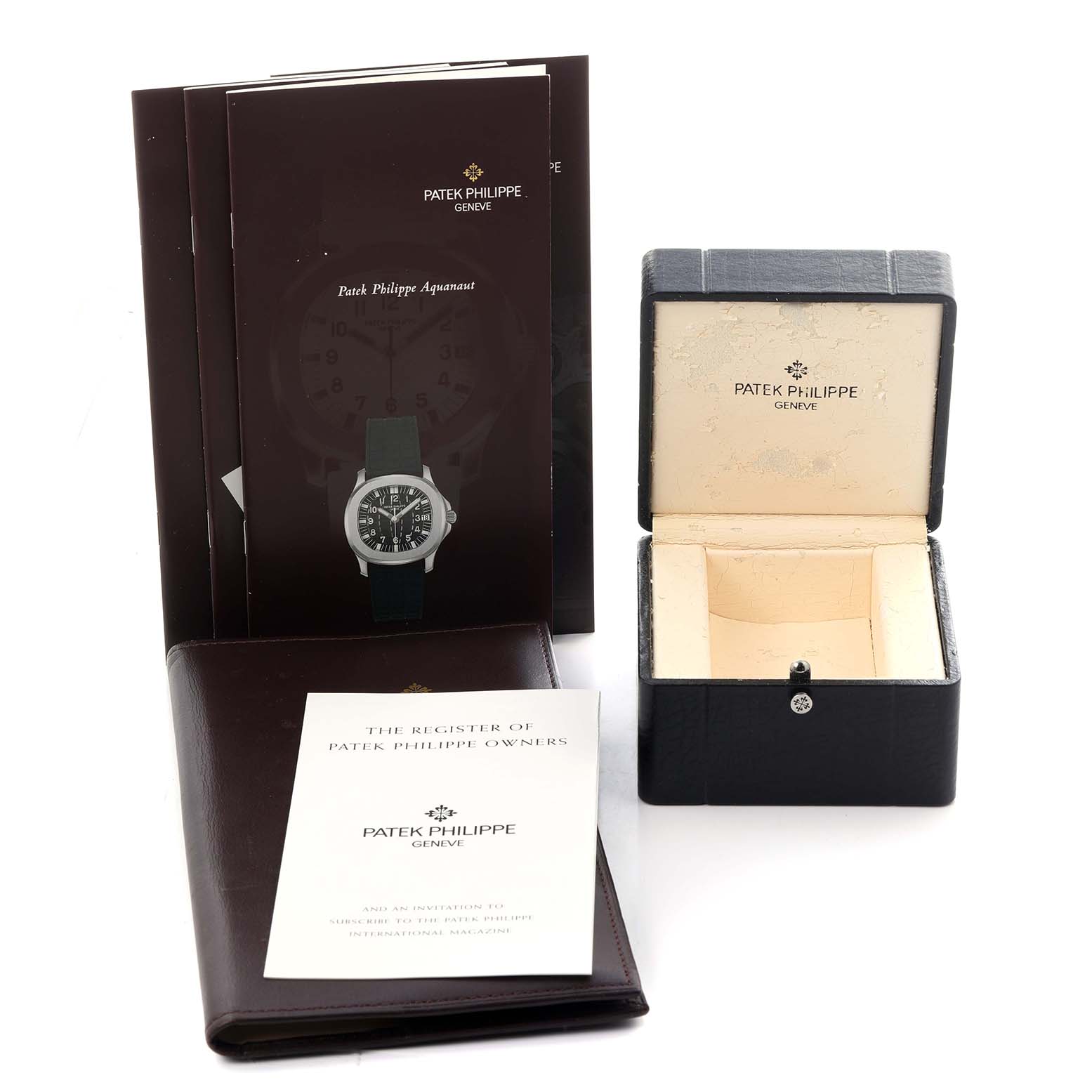 The image shows Patek Philippe Aquanaut 5067A-027 Women's Stainless Steel Red Dial 5067A-027 Women's Stainless Steel Red Dial accessories including the box, booklets, and registration document from a slightly elevated angle.