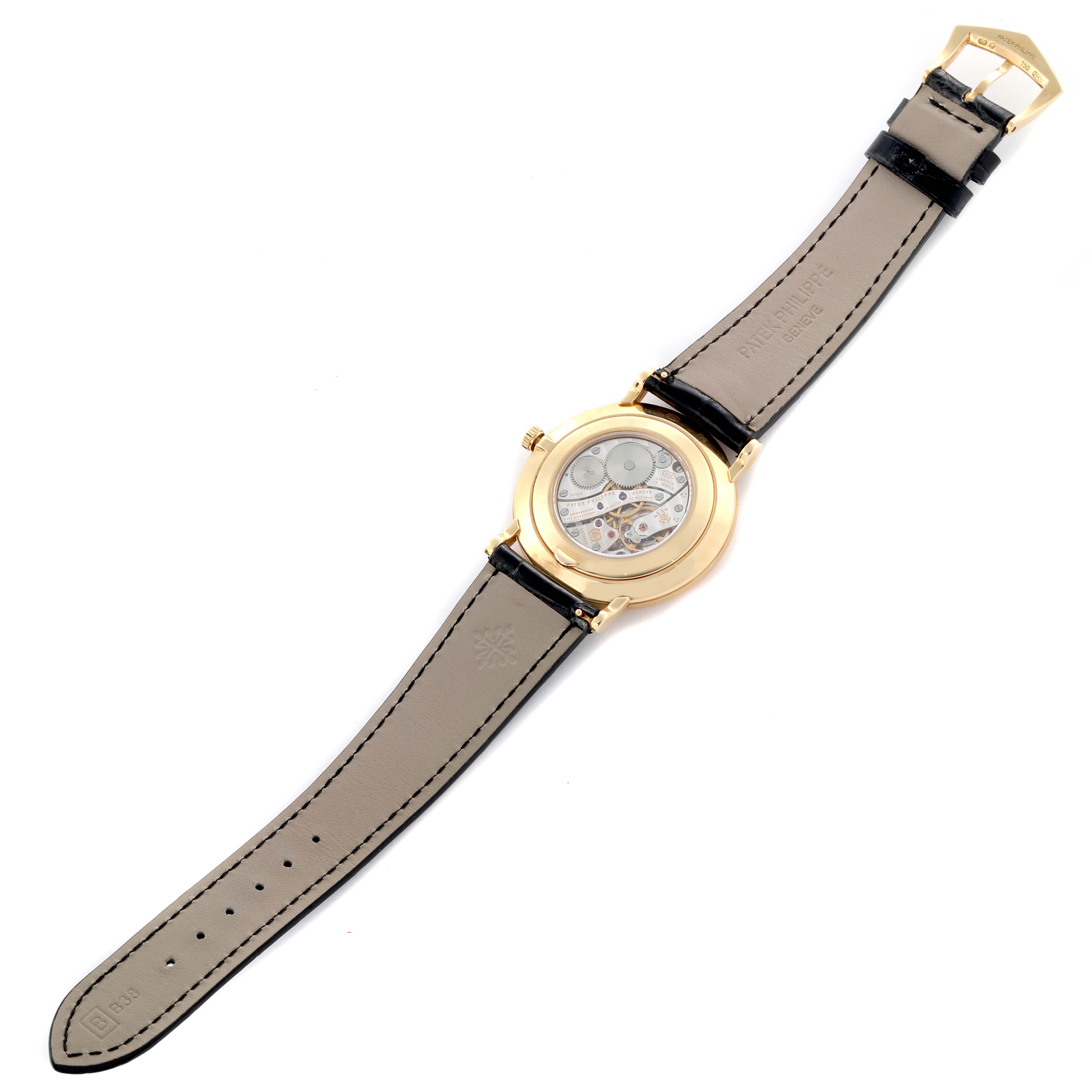 The image shows the back view of a Patek Philippe Calatrava 5119J-001 Men's Yellow Gold White Dial 5119J-001 Men's Yellow Gold White Dial watch, highlighting its exposed movement and leather strap.