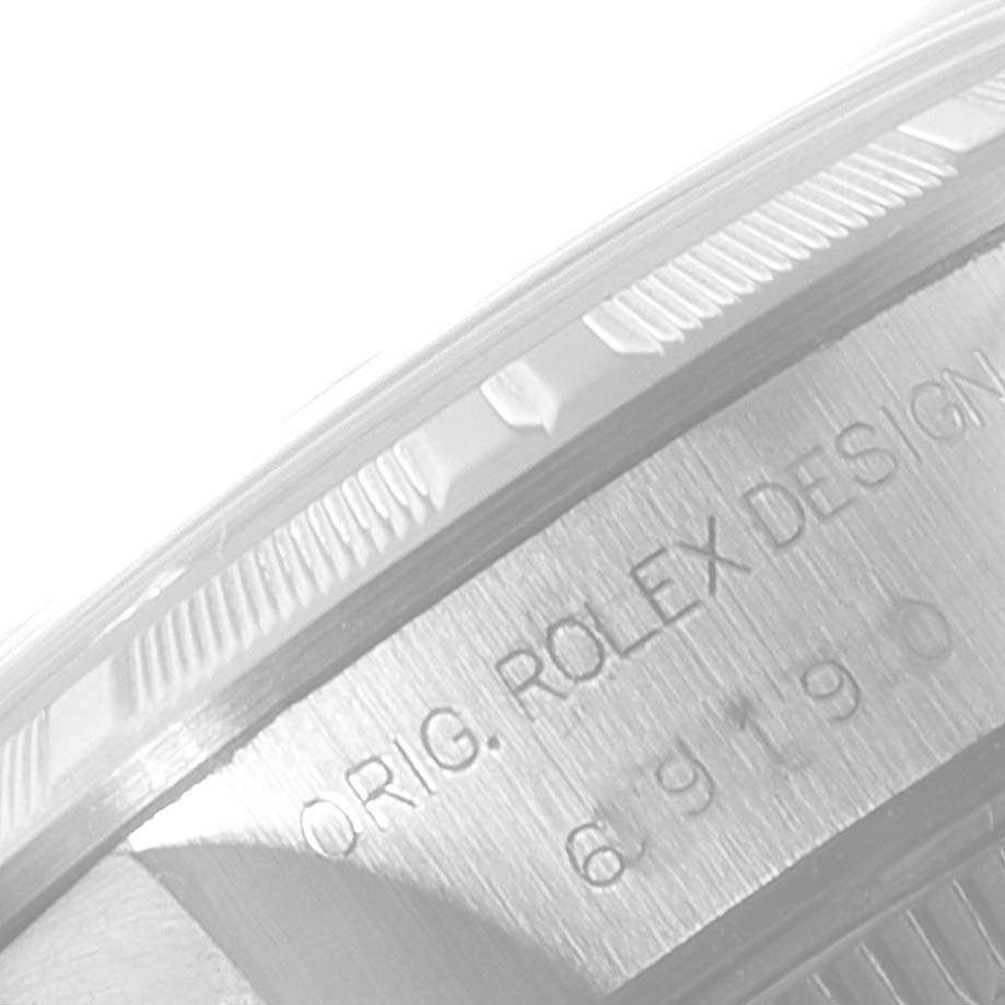 This image shows a close-up of the side of a Rolex Date 69190 Women's Stainless Steel White Dial 69190 Women's Stainless Steel White Dial model watch, displaying its design engravings.