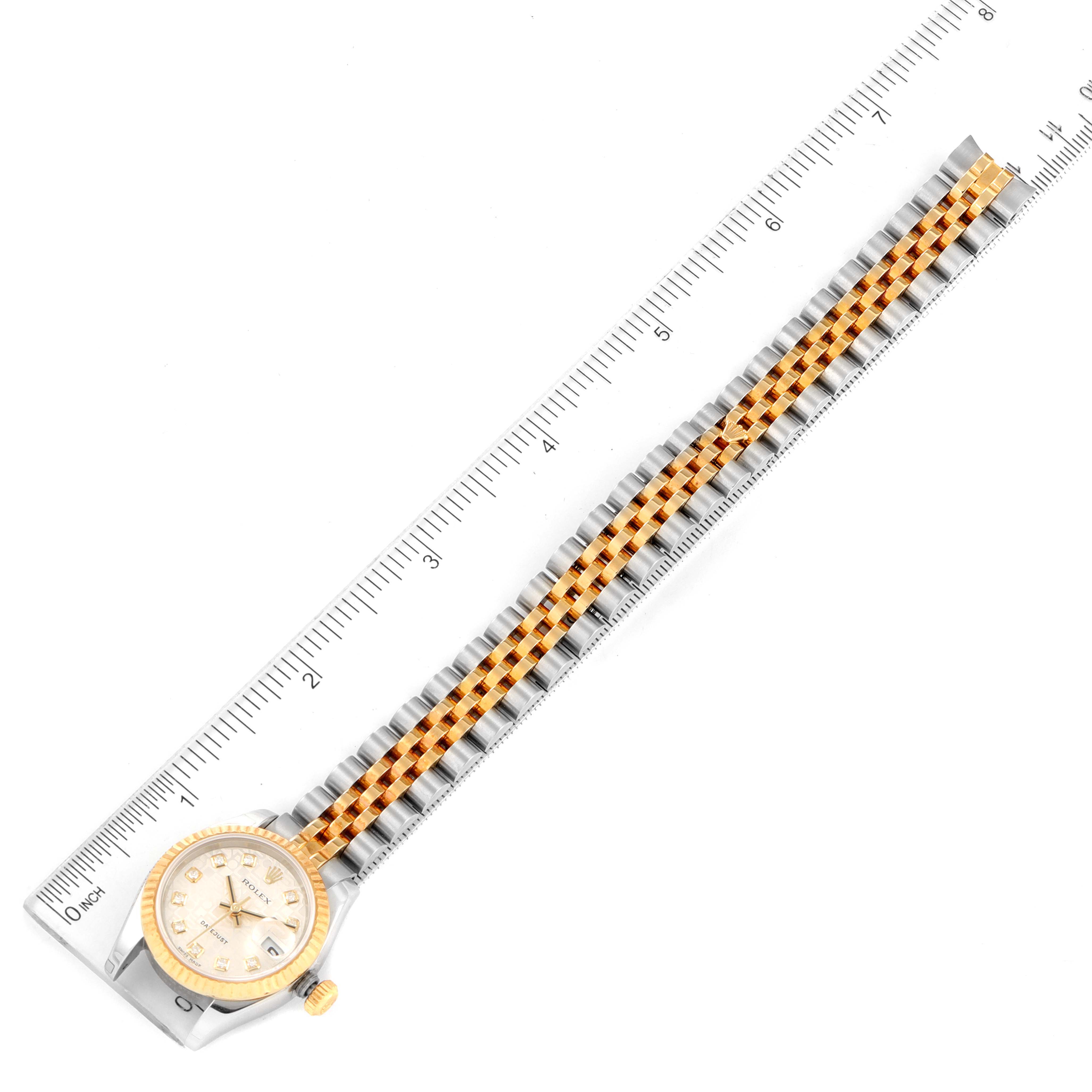 The image shows a top view of a Rolex Datejust 179173 Women
s Steel and Gold (two tone) Silver Dial 179173 Women
s Steel and Gold (two tone) Silver Dial watch beside a ruler, highlighting its bracelet length.