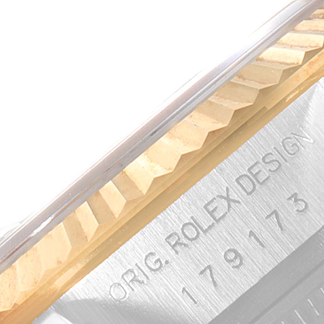 This image shows a close-up angle of the fluted bezel and part of the case with engravings on a Rolex Datejust 179173 Women
s Steel and Gold (two tone) Silver Dial 179173 Women
s Steel and Gold (two tone) Silver Dial watch.