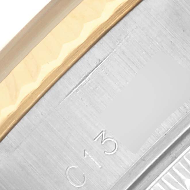 The image shows a close-up of the side of a Rolex Datejust 69173 Women's Steel and Gold (two tone) White Dial 69173 Women's Steel and Gold (two tone) White Dial watch, highlighting the edge of the bezel and part of the case with engraved markings.