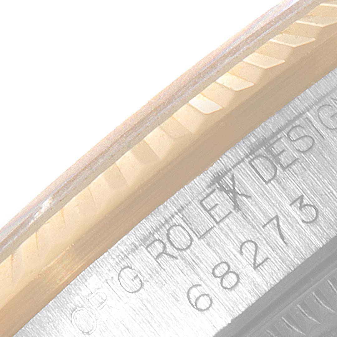 The image shows a close-up of the model and design engravings on a Rolex Mid-Size 68273 Women
s Steel and Gold (two tone) Black Dial 68273 Women
s Steel and Gold (two tone) Black Dial watch
s case, along with part of the bezel.