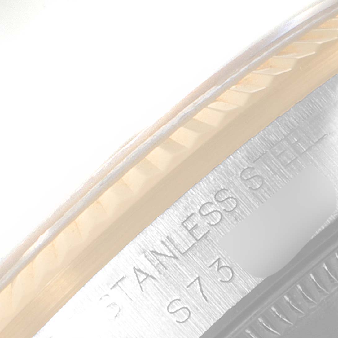 This close-up image of a Mid-Size Rolex watch shows the bezel and part of the stainless steel casing.