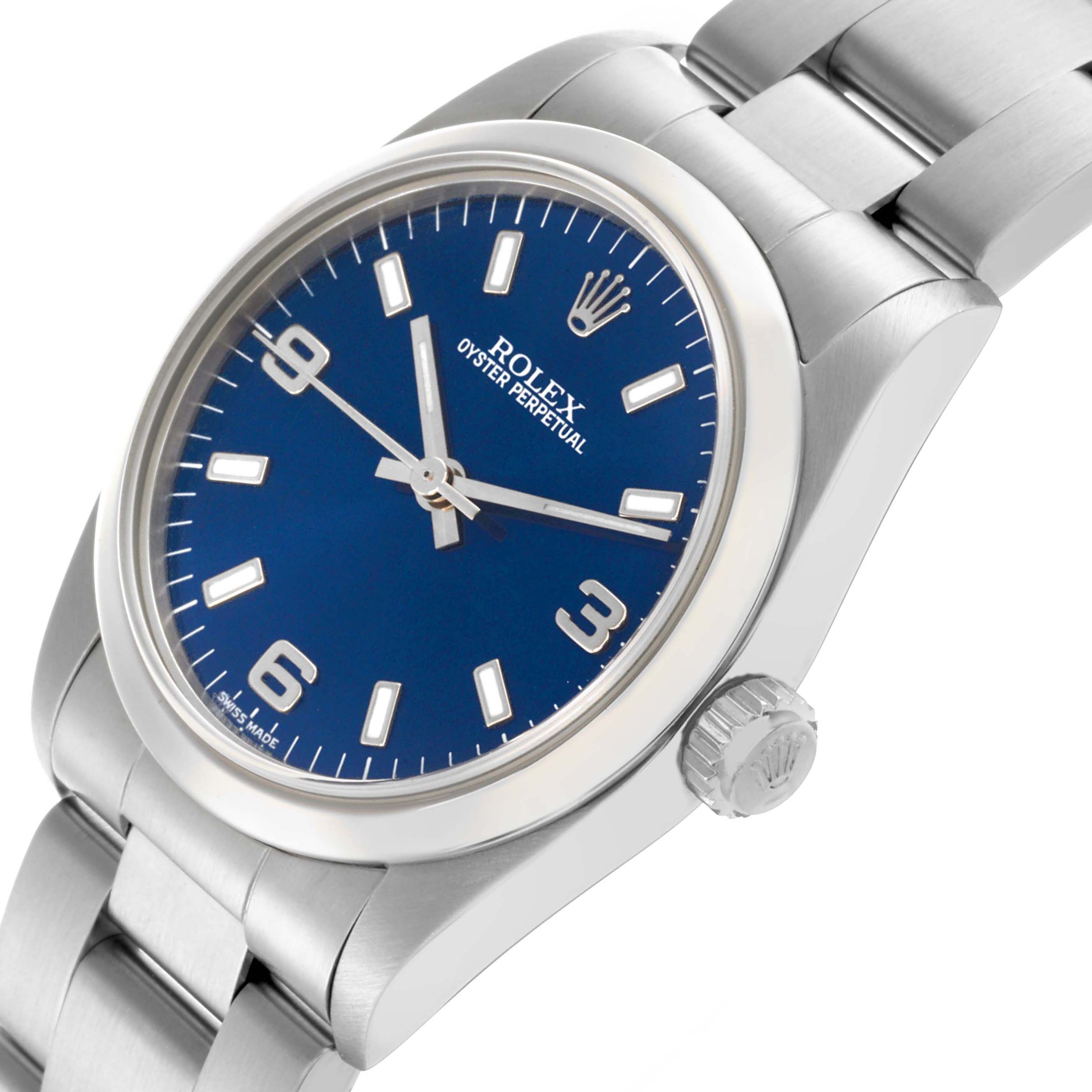 The Rolex Mid-Size 77080 Women's Stainless Steel Blue Dial 77080 Women's Stainless Steel Blue Dial watch is shown at a tilted angle, highlighting the blue dial, bezel, crown, and metal bracelet.