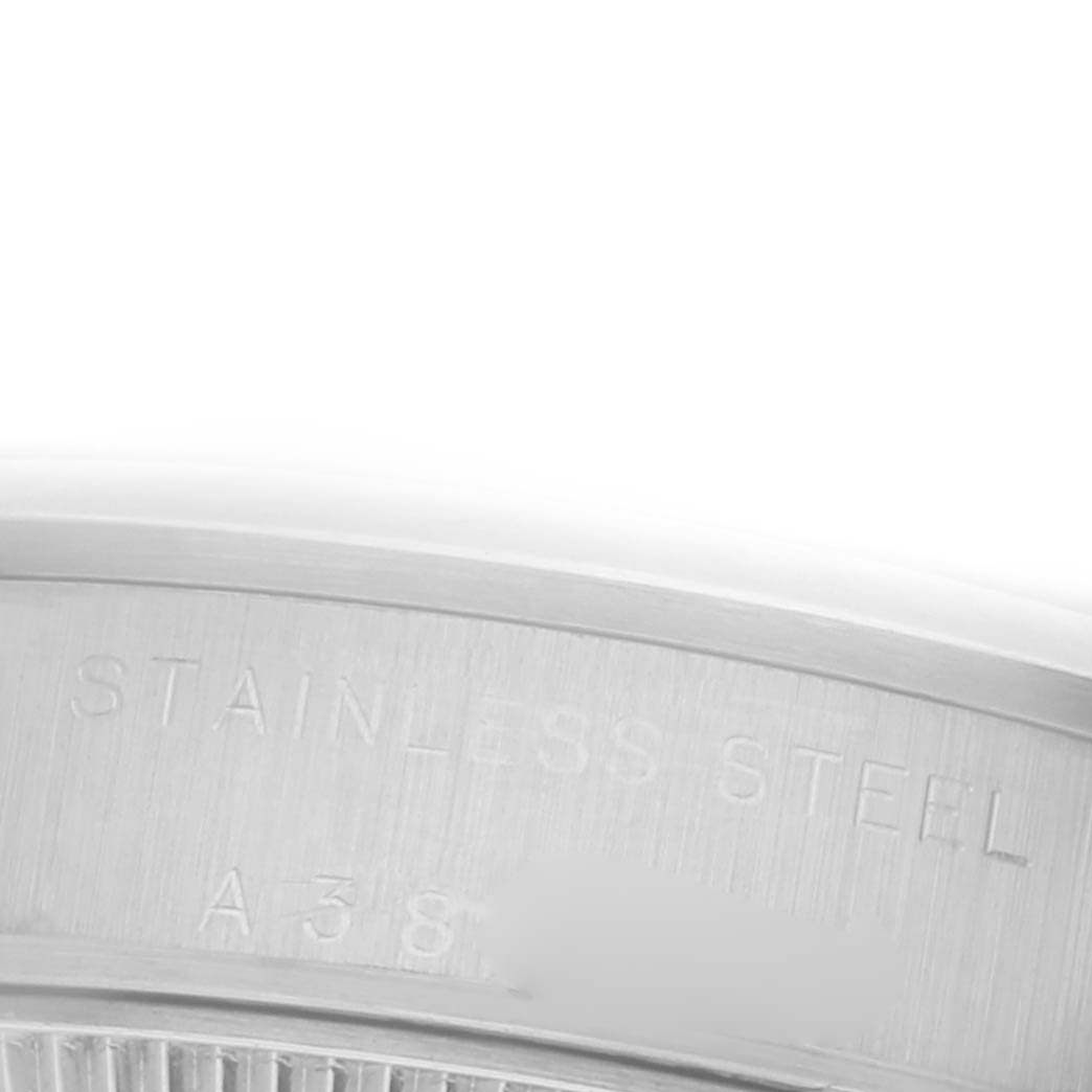 The image shows a close-up of the case back edge of a Mid-Size Rolex, focusing on the stainless steel inscription.