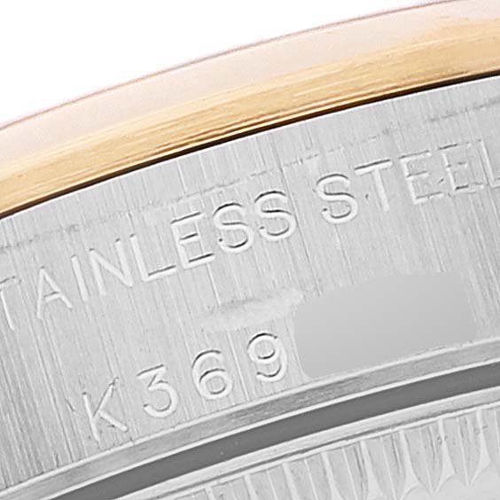 The image shows a close-up of the case back edge of a Rolex Oyster Perpetual 76183 Women's Steel and Gold (two tone) Grey Dial 76183 Women's Steel and Gold (two tone) Grey Dial watch, highlighting the stainless steel material and a partial serial number.